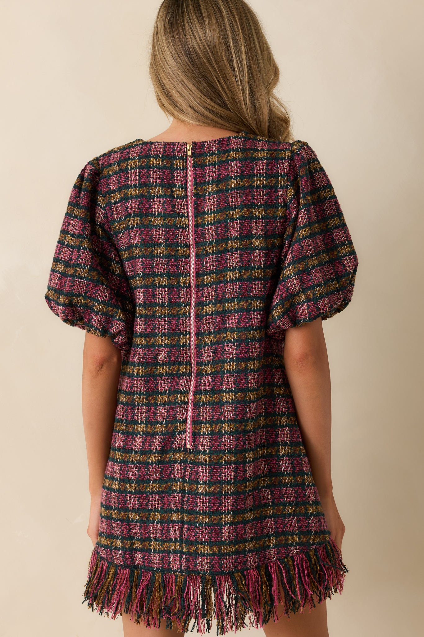 Rear view of the plaid tweed mini dress showing the functional zipper closure and clean shift shape.