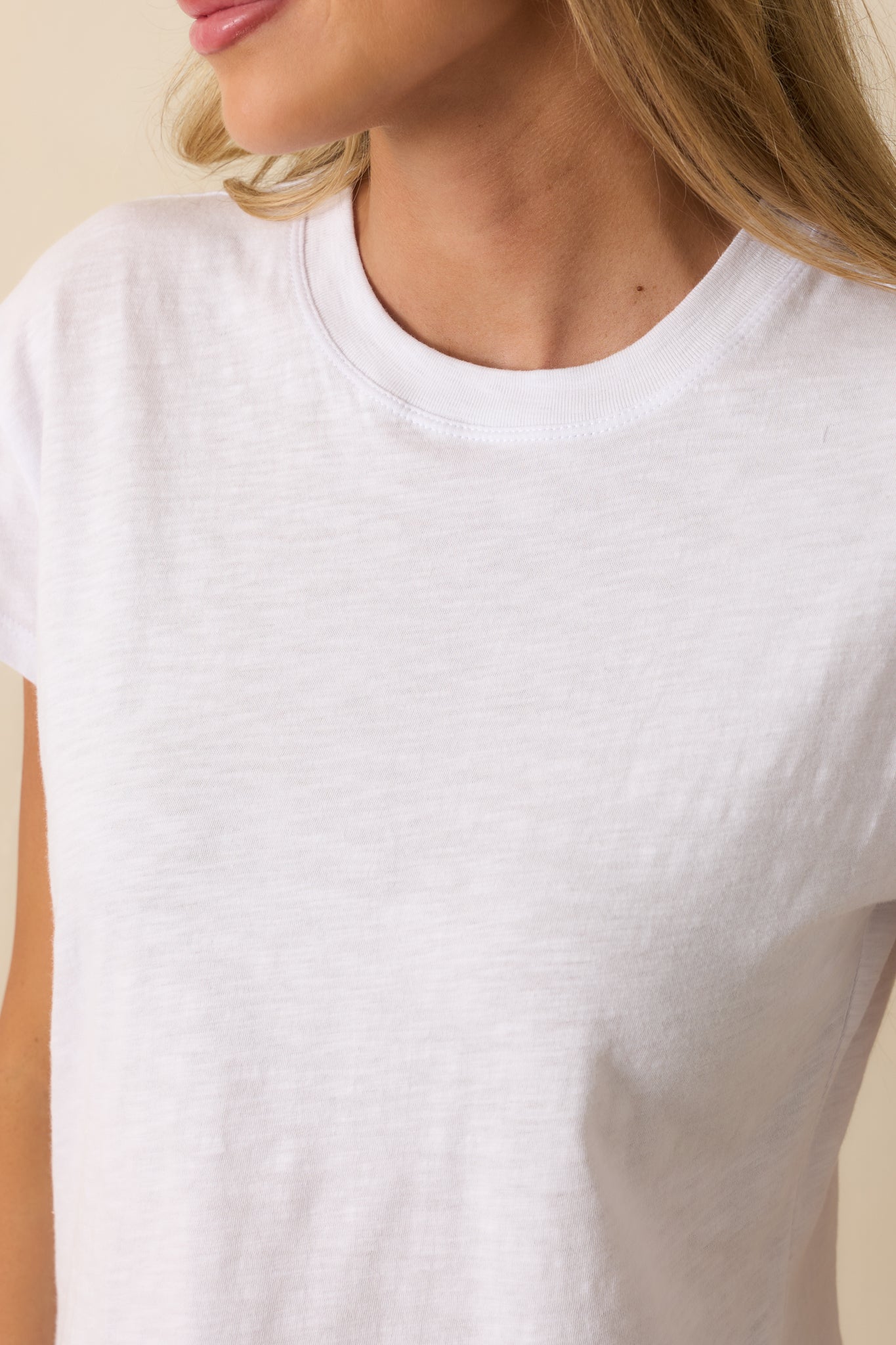 Close up of white tee showcasing the lightweight material and crew neckline.