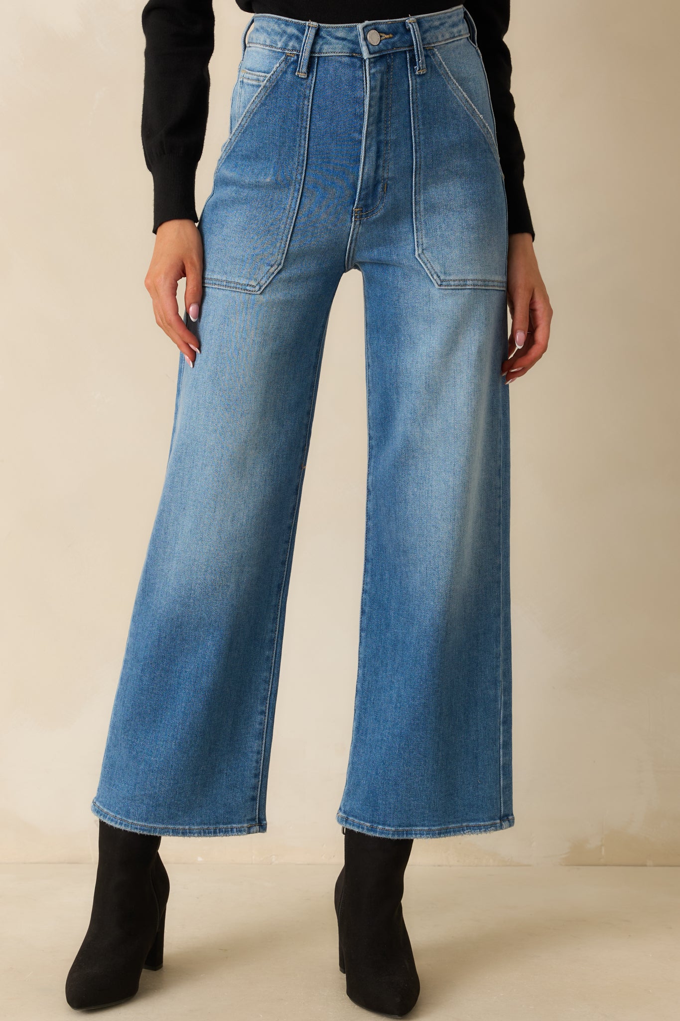 Focus on the slight distressing and texture of the medium wash denim.