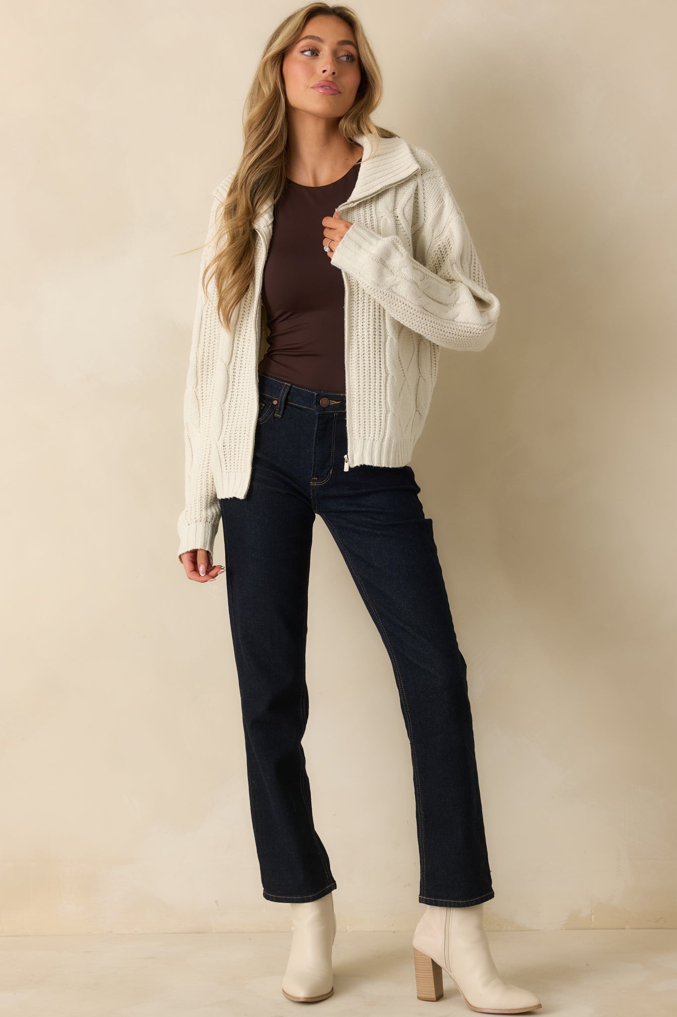 Straight front shot showing the long sleeves and relaxed fit of the ivory knit jacket.