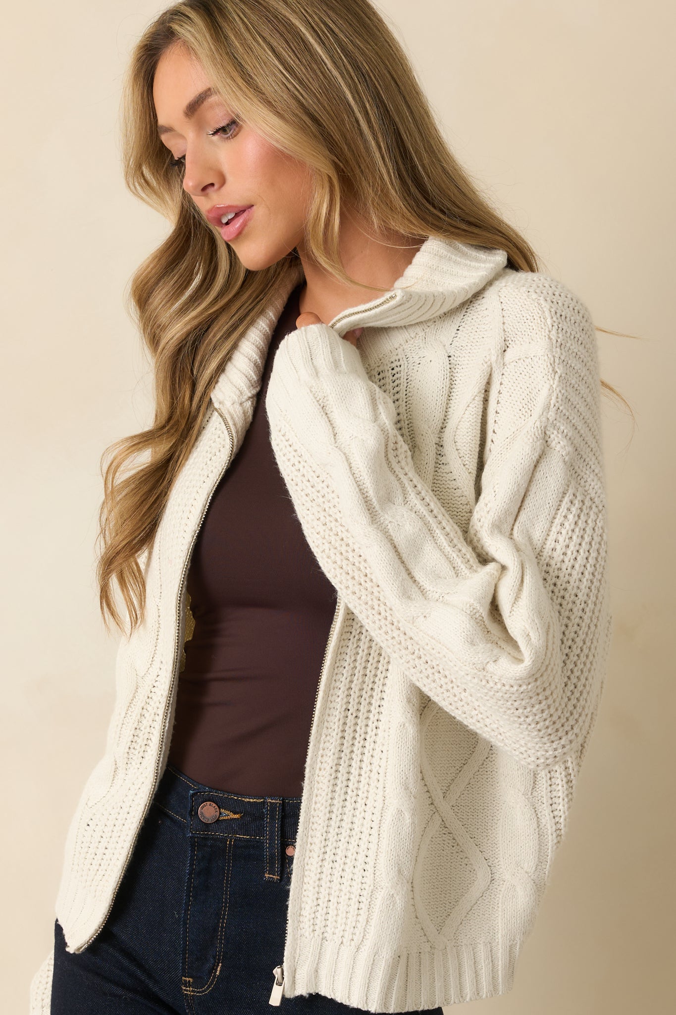 Cropped side view emphasizing the ribbed hems and cable knit texture along the sleeves.