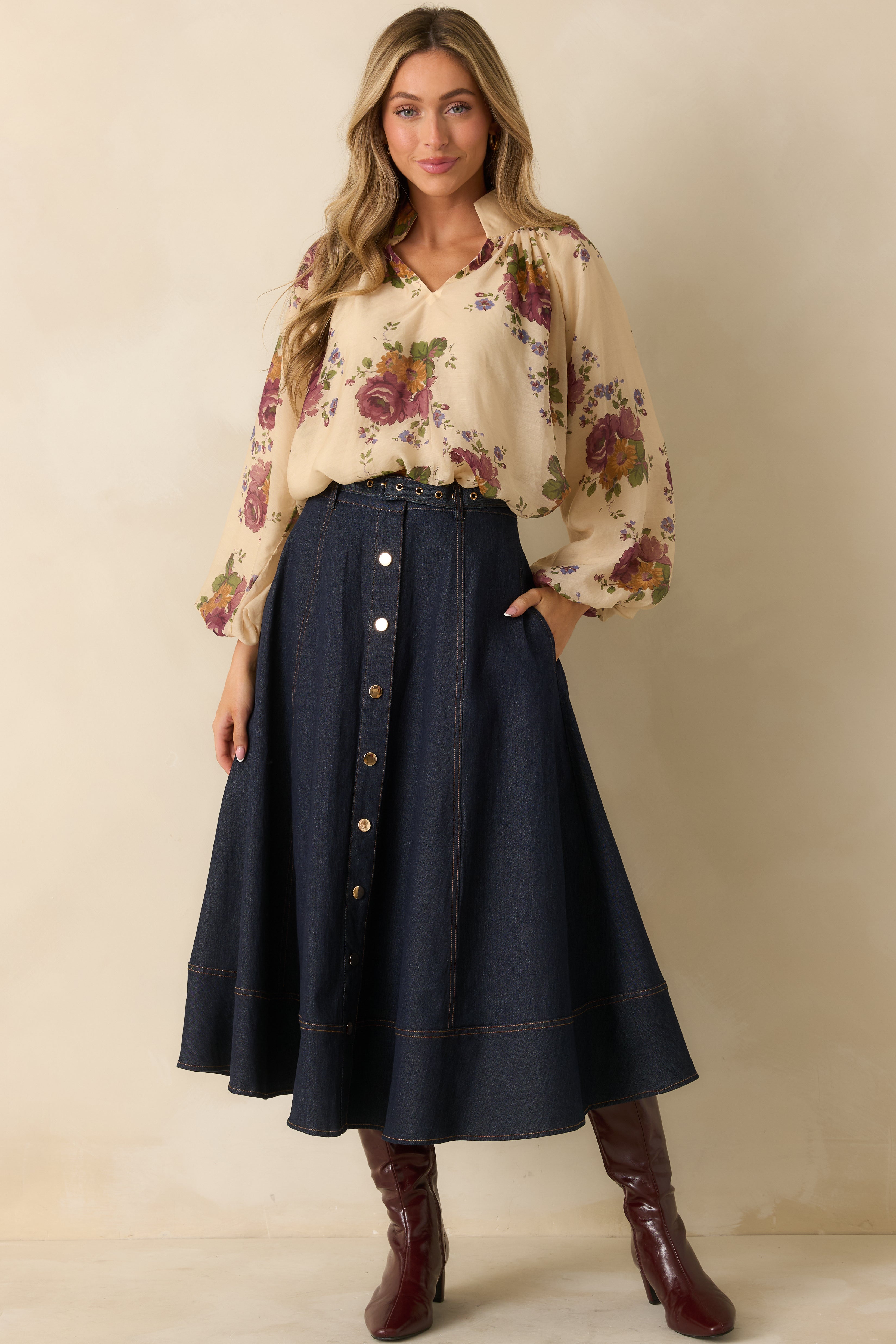 Front view of dark wash skirt showing the high-rise waist, snap button front, and overall paneled design.