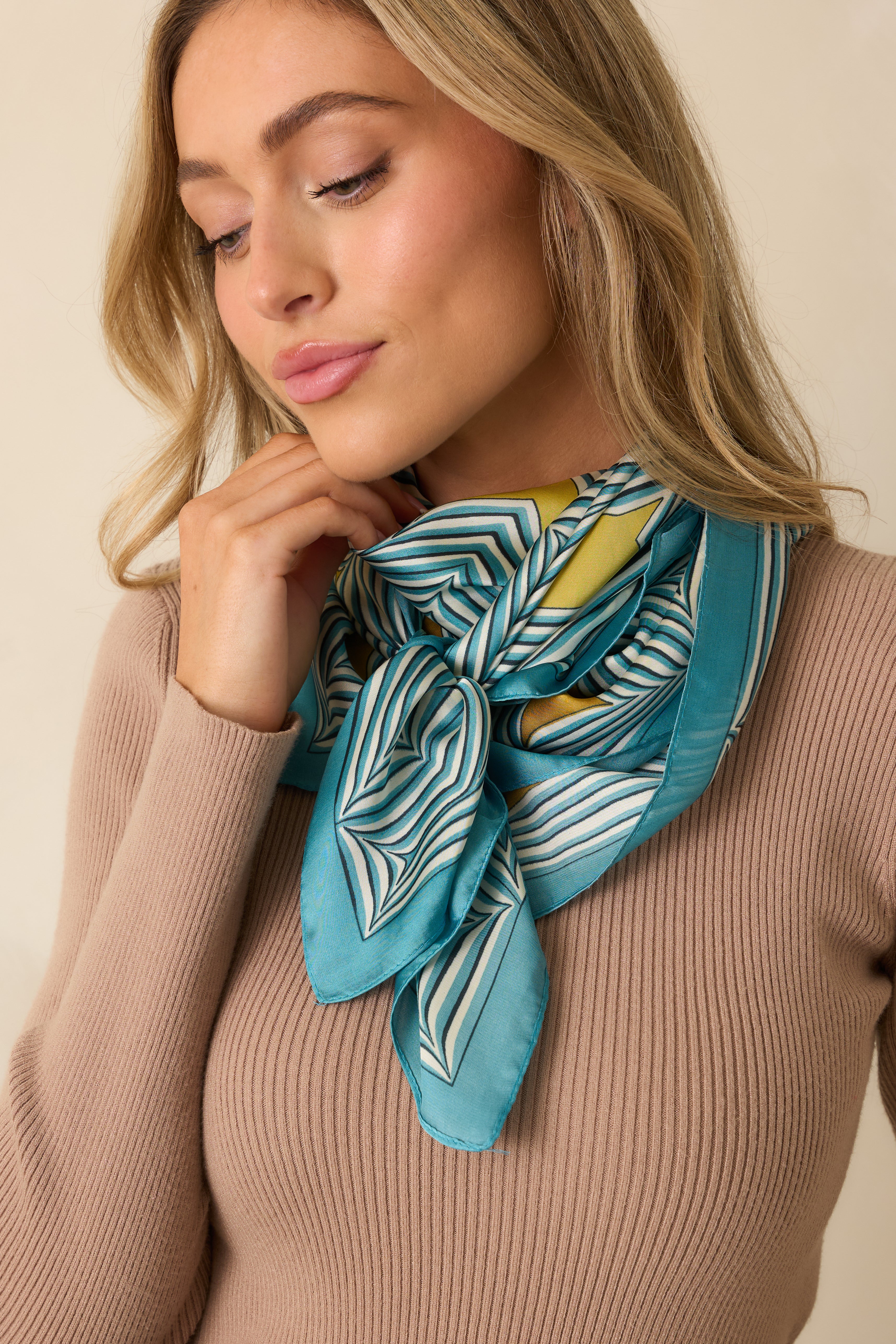 Close crop emphasizing the satin texture and pattern of the blue scarf.