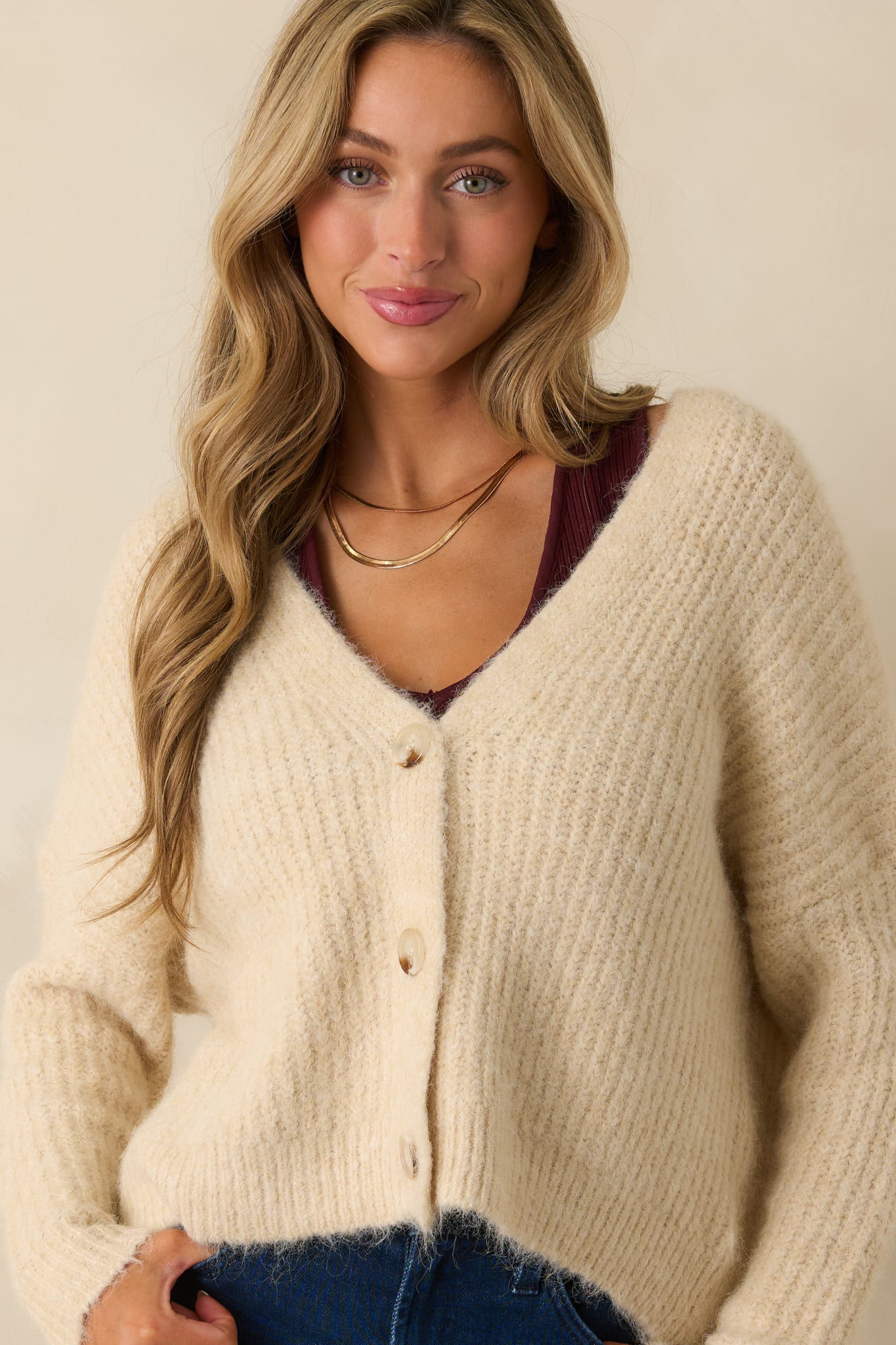 Cropped front view highlighting the tortoise shell buttons and ribbed fabric along the neckline and front.