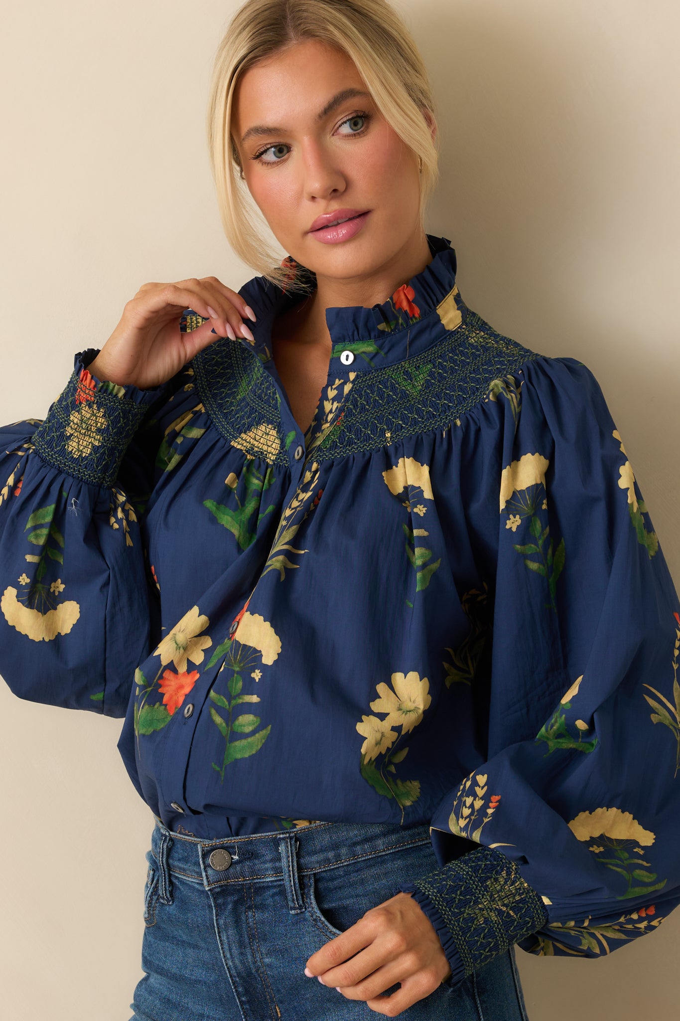 Close view of the midsection showing the smocked waist detail, button-front closure, and embroidered floral pattern.
