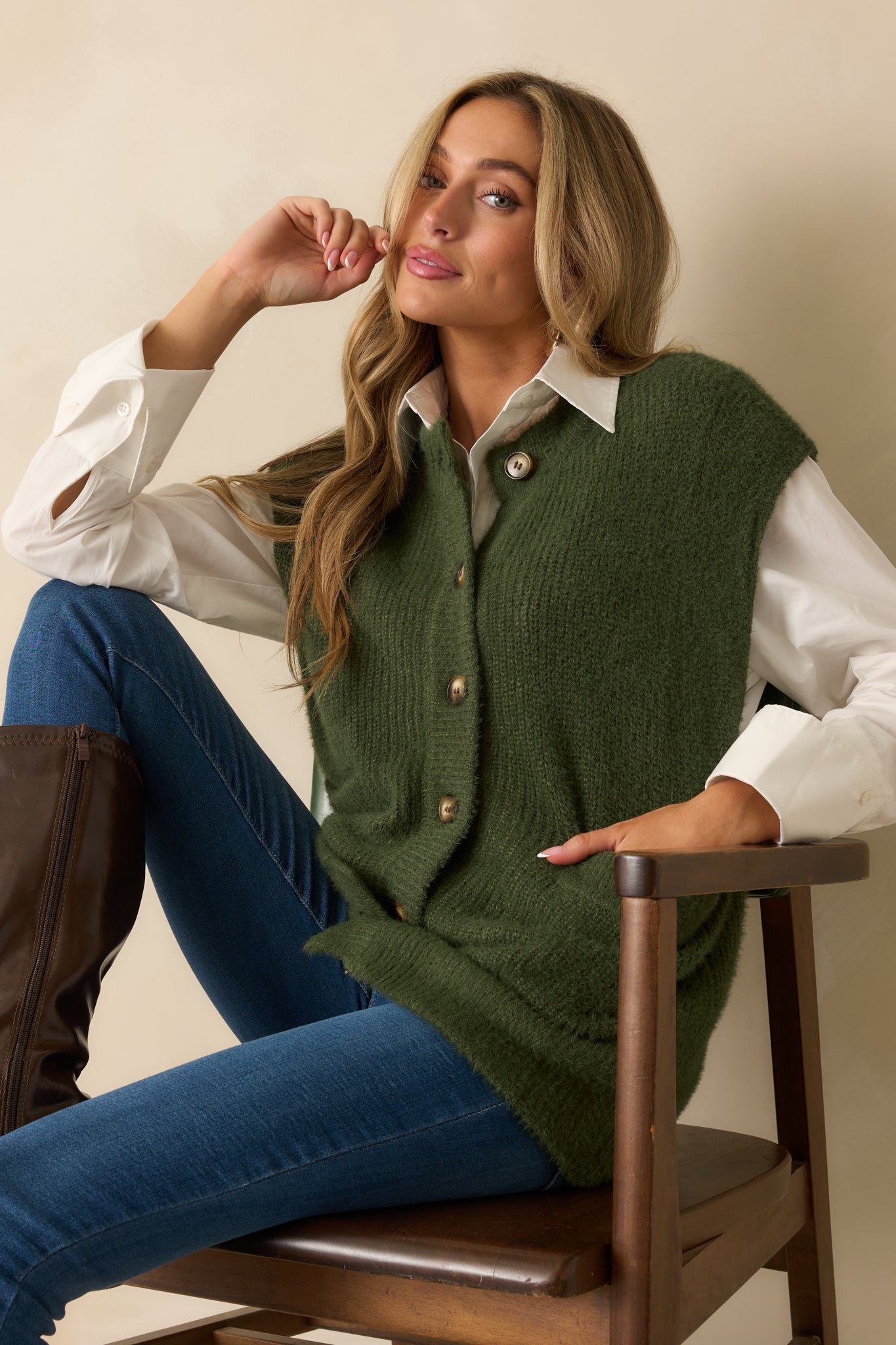 Green sleeveless knit cardigan drapes in a relaxed shape with tidy button closures and roomy patch pockets.