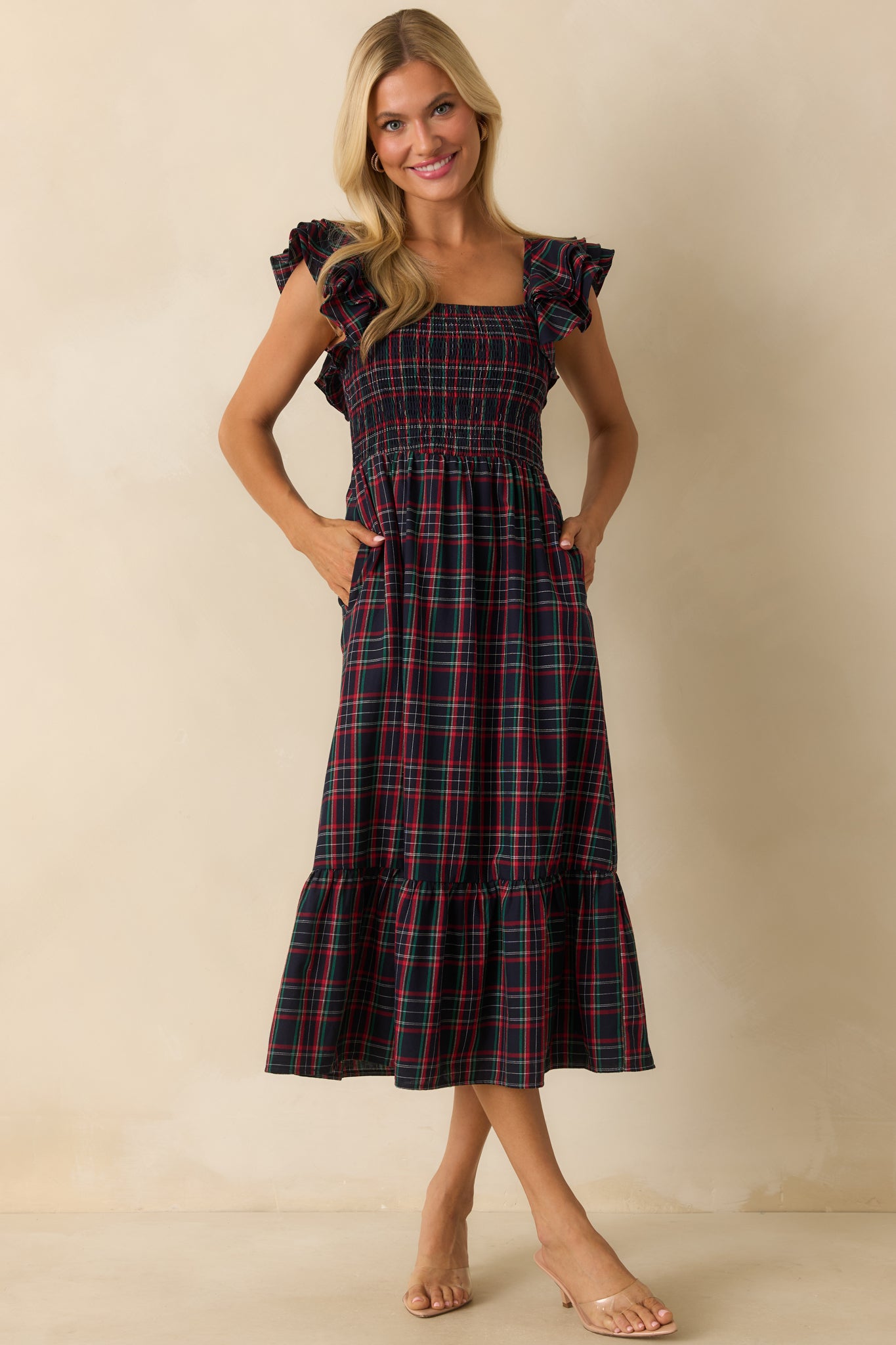 Navy dress showcasing flutter sleeves, smocked bodice, square neckline, and tiered skirt movement.