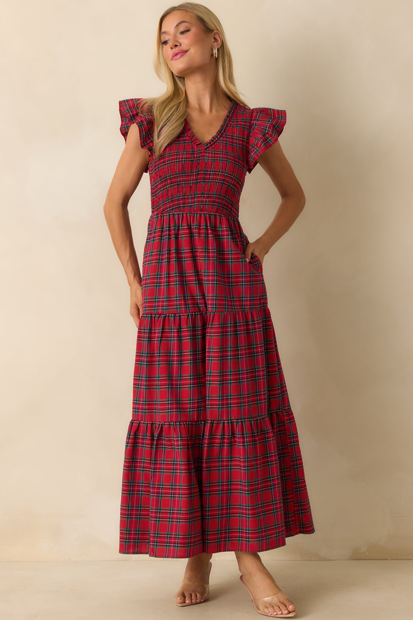Front view of red dress showcasing fully smocked bodice, flowing tiered skirt, and flutter sleeves.