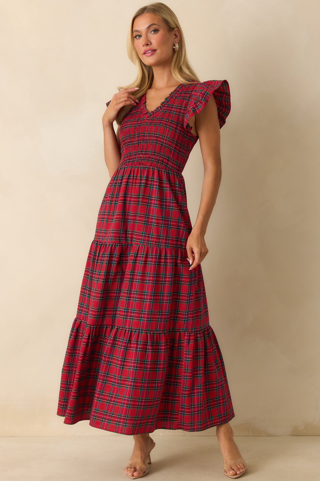 Maxi dress in red plaid featuring a v-neckline, fitted smocking, and layered skirt tiers.