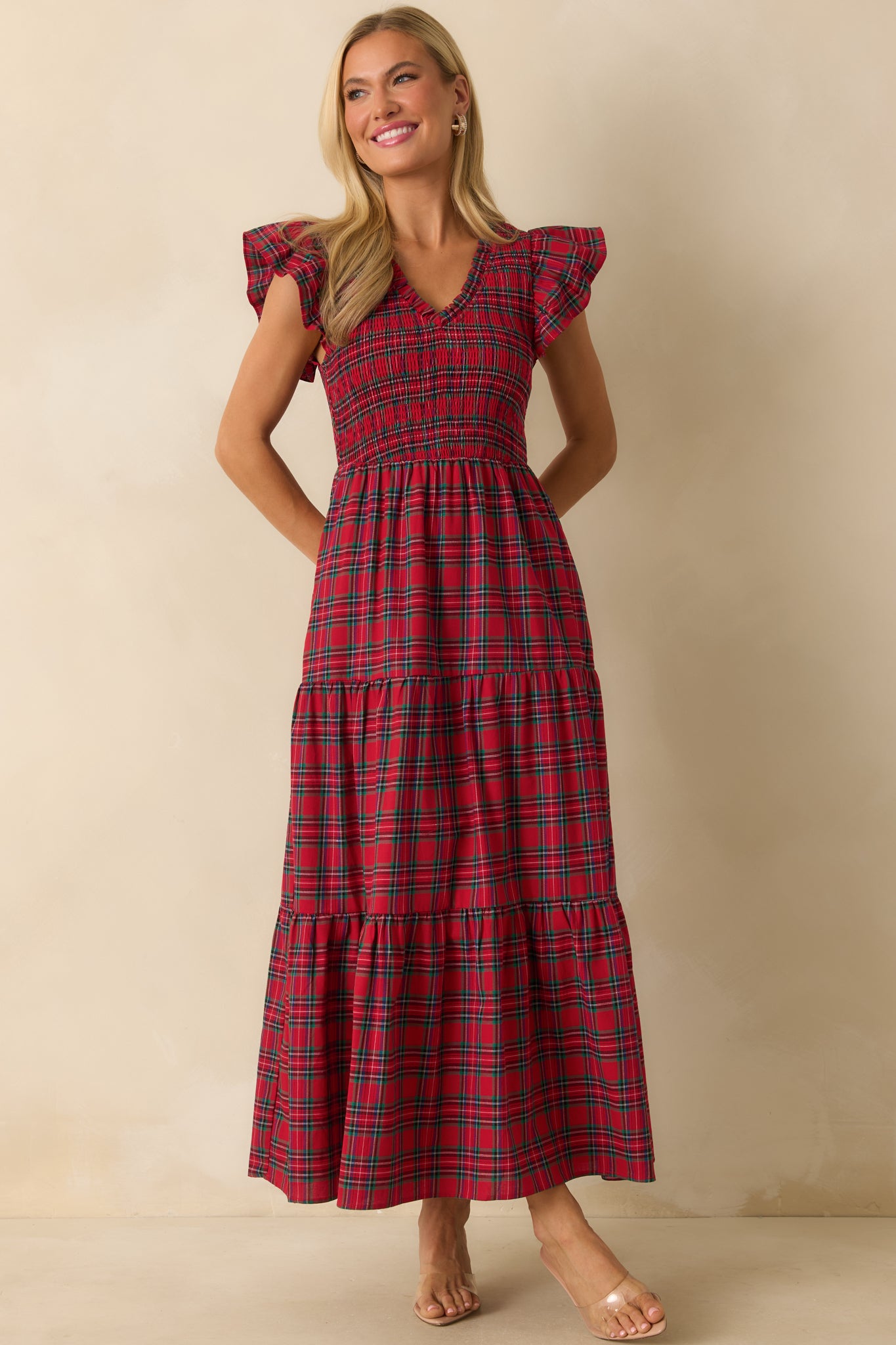 Slim-fit red maxi dress with a v-neckline, smocked top, tiered skirt, and flutter sleeve detail.
