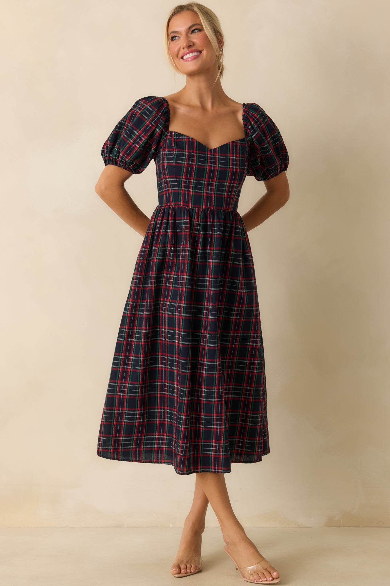 Navy dress featuring a sweetheart neckline, short puff sleeves, and gently fitted silhouette.