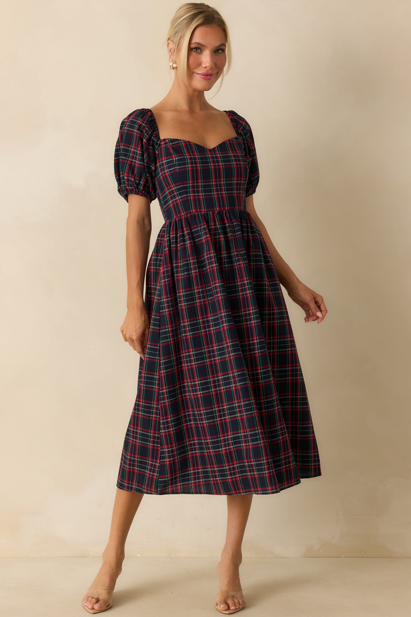 Flowing navy dress showing a sweetheart neckline, short puff sleeves, and plaid print design.