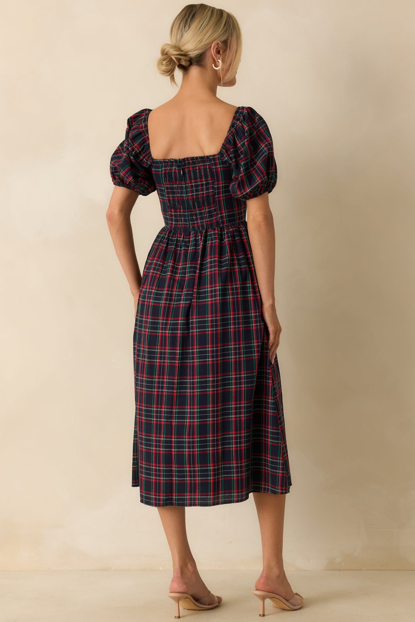 Rear view of navy plaid dress showing smocked back panel, discrete zipper closure, and short puff sleeves.