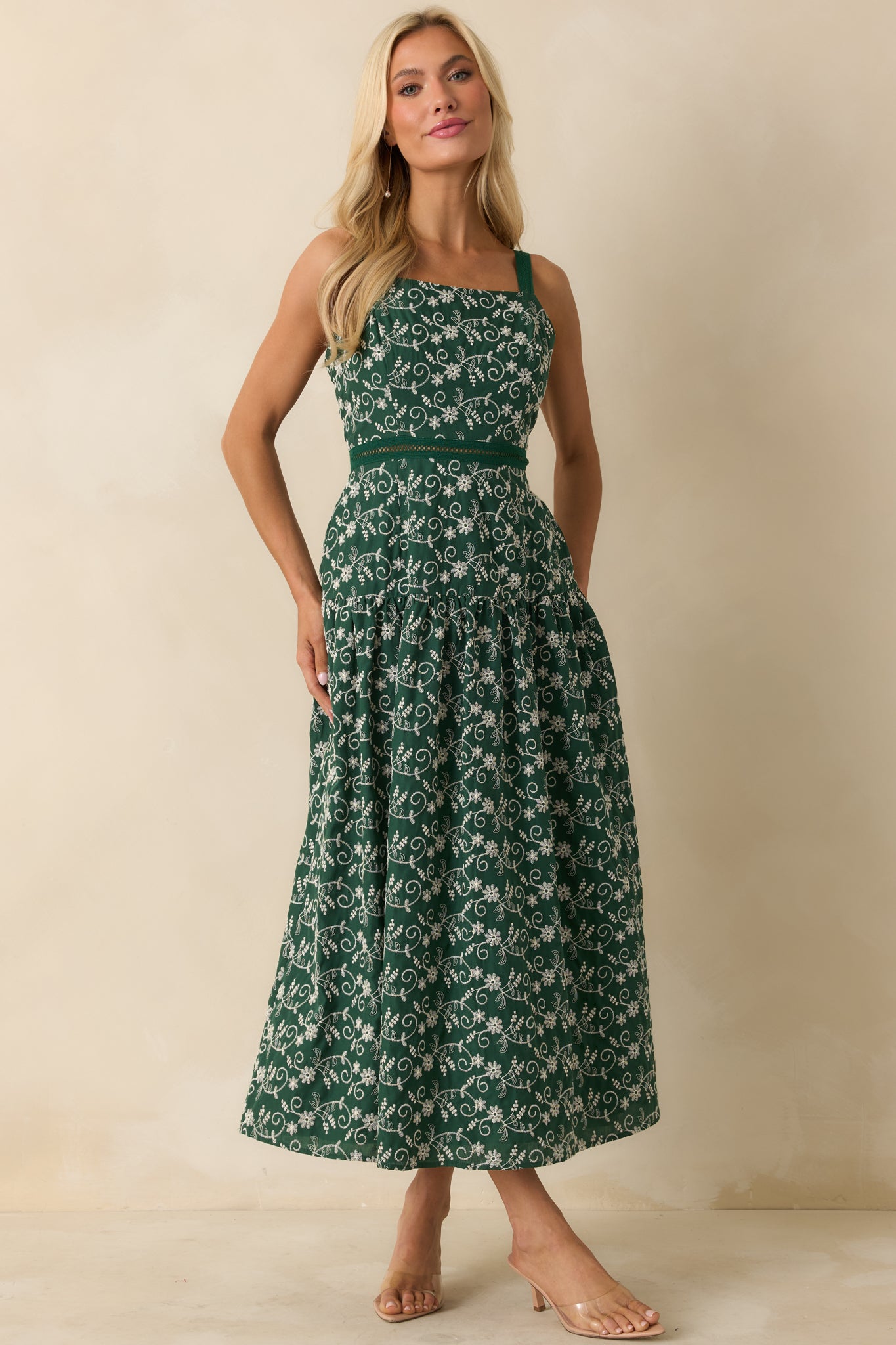 Front view of hunter green dress featuring open ladder-lace waist detail and flowing full-length silhouette.