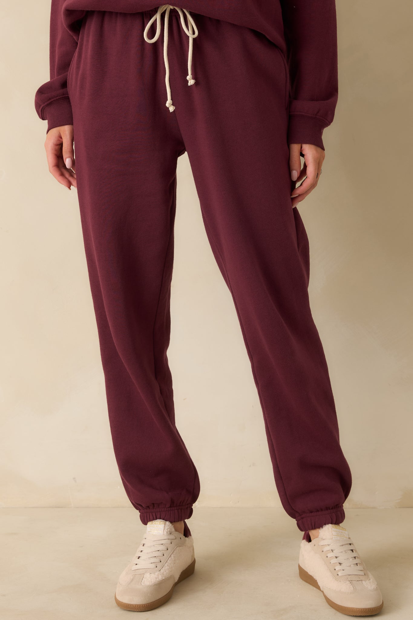 Focus on the waistband and smooth fleece material, showing the relaxed structure of the joggers.
