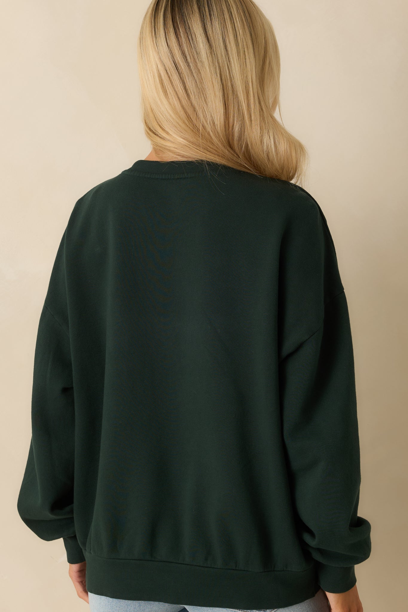 Rear view of green oversized sweatshirt, highlighting long sleeves, relaxed silhouette, and smooth brushed cotton fleece finish.