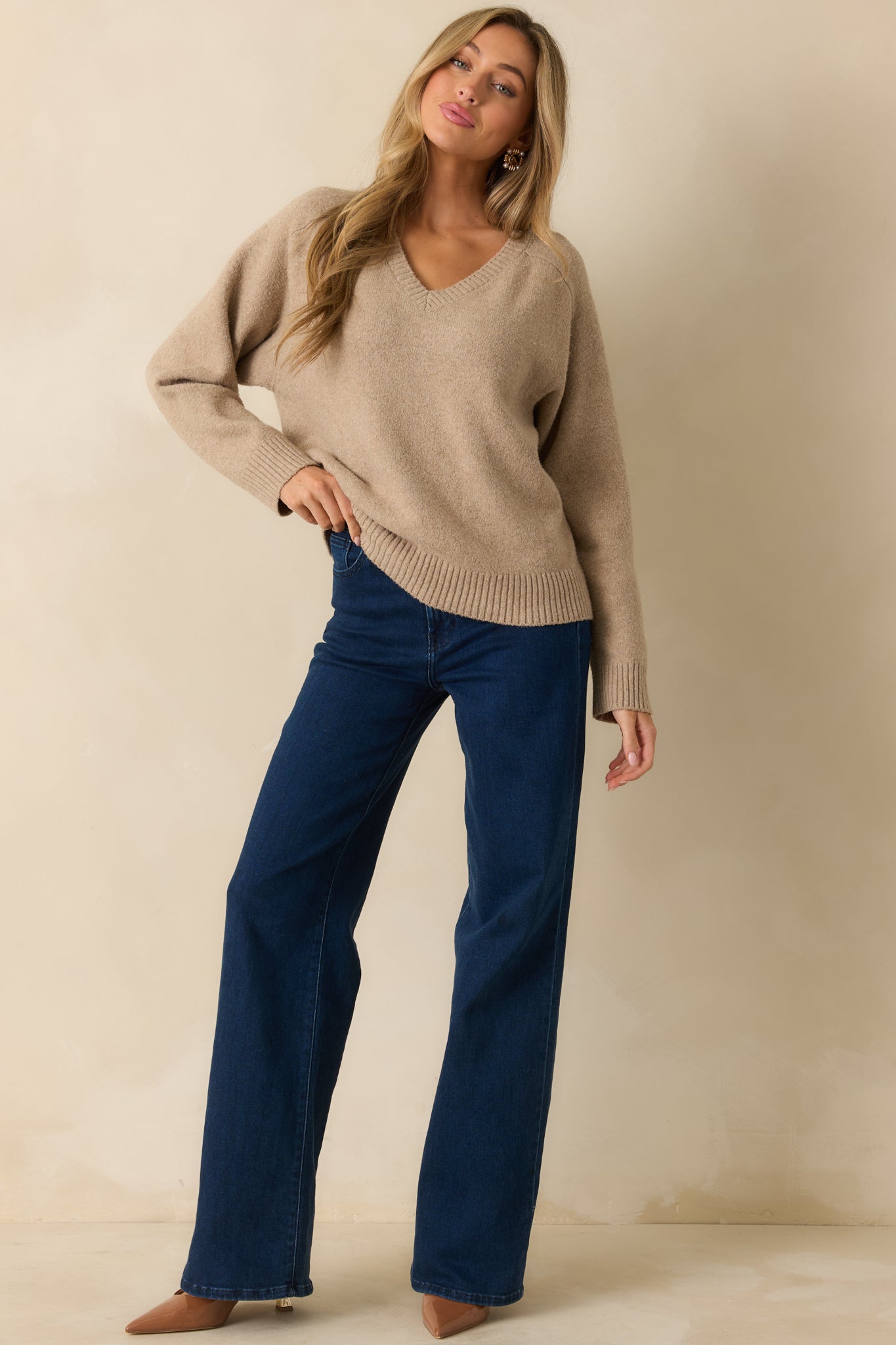 Beige V-neck sweater with a relaxed silhouette and soft mid-weight knit fabric.