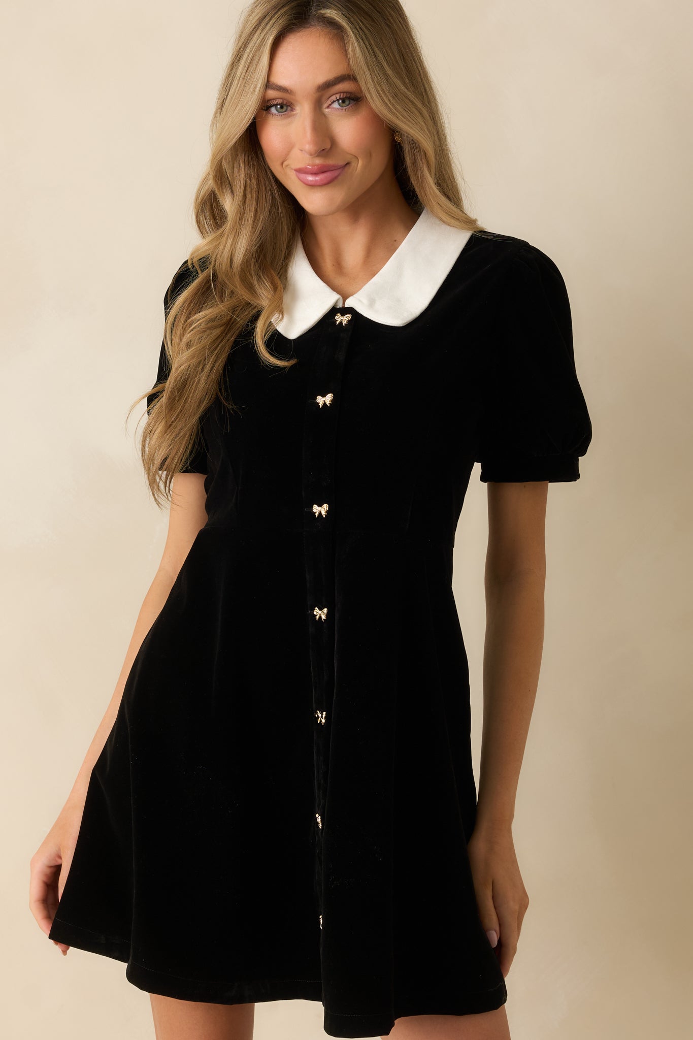 Focus on the side pockets and rich black velvet fabric of the mini dress.