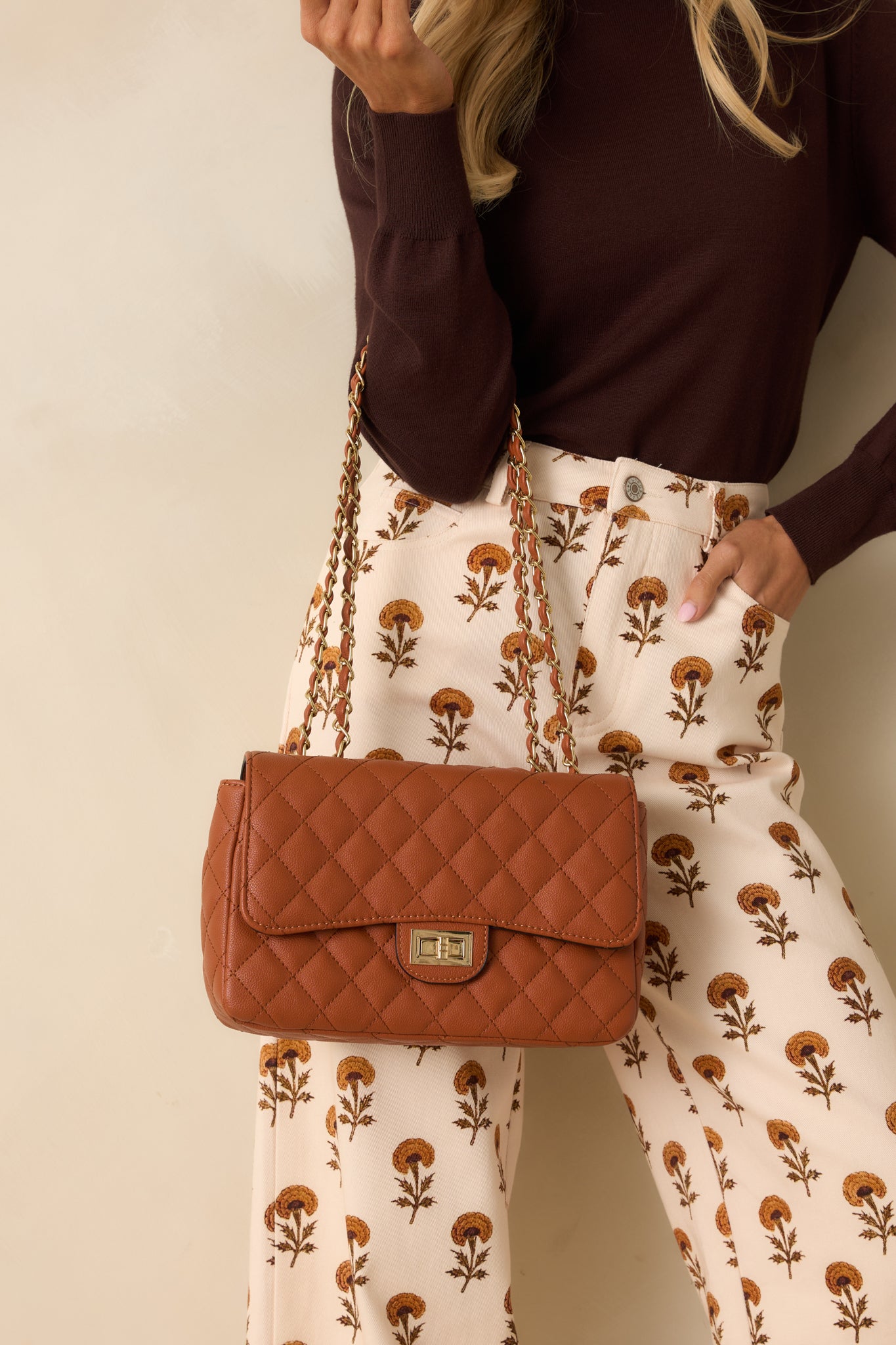 Quilted ginger brown bag featuring a crossbody chain strap and structured rectangular shape.
