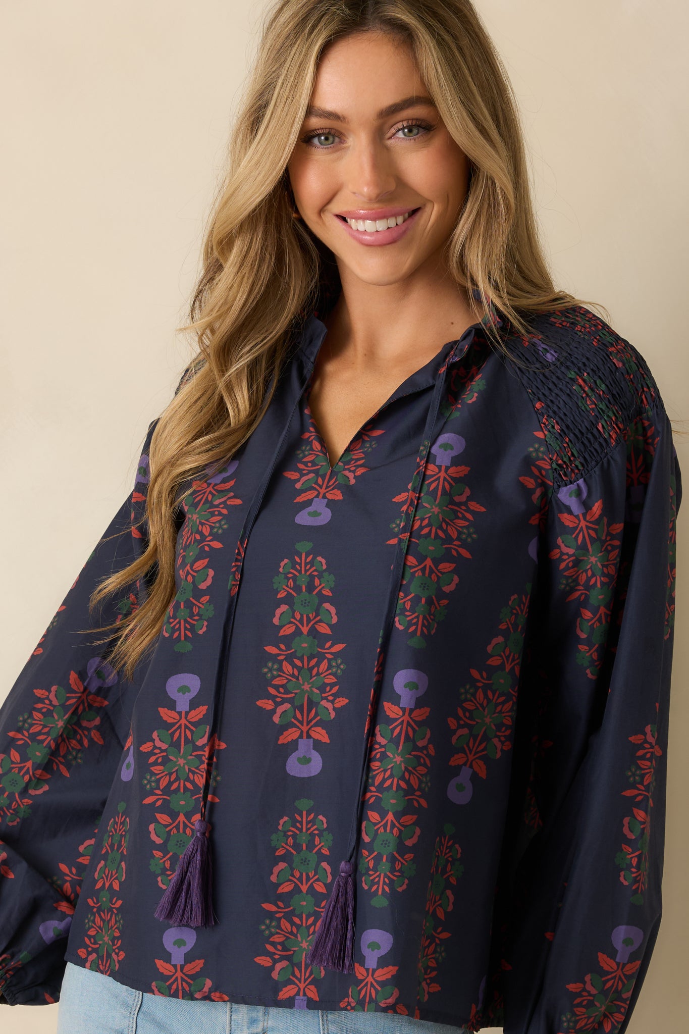 Cotton navy top featuring smocked shoulders, long puff sleeves, and elastic cuffs for a comfortable fit.