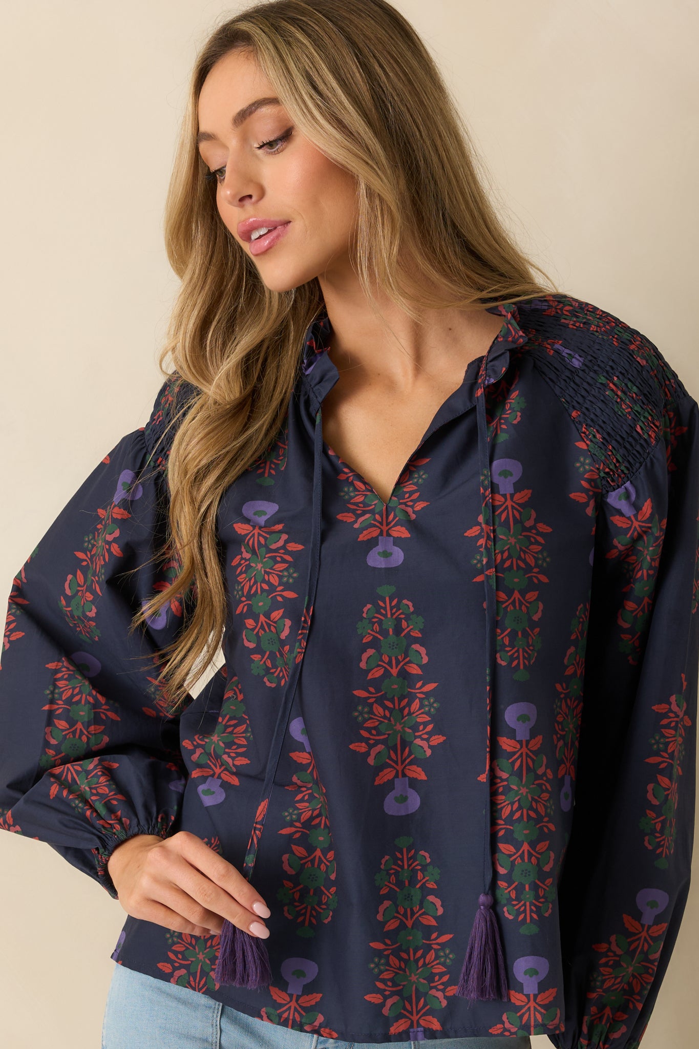 Cropped view of the navy floral top emphasizing the smocked shoulders, puff sleeve texture, and neckline tie detail.