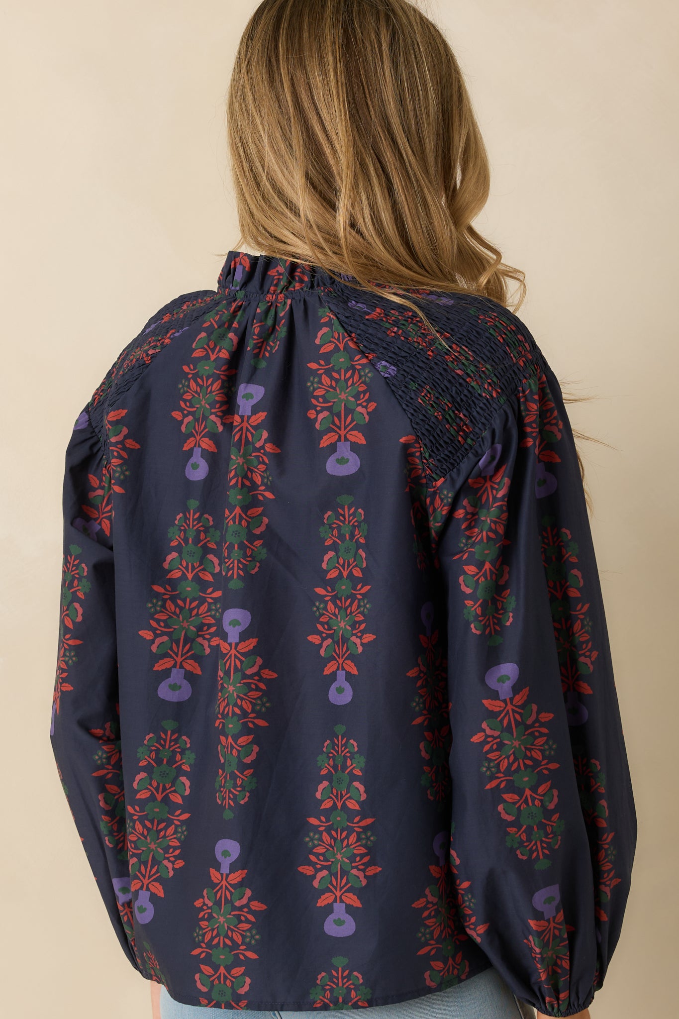 Rear view of the navy multi peasant top displaying the smooth back fabric and puff sleeve silhouette.
