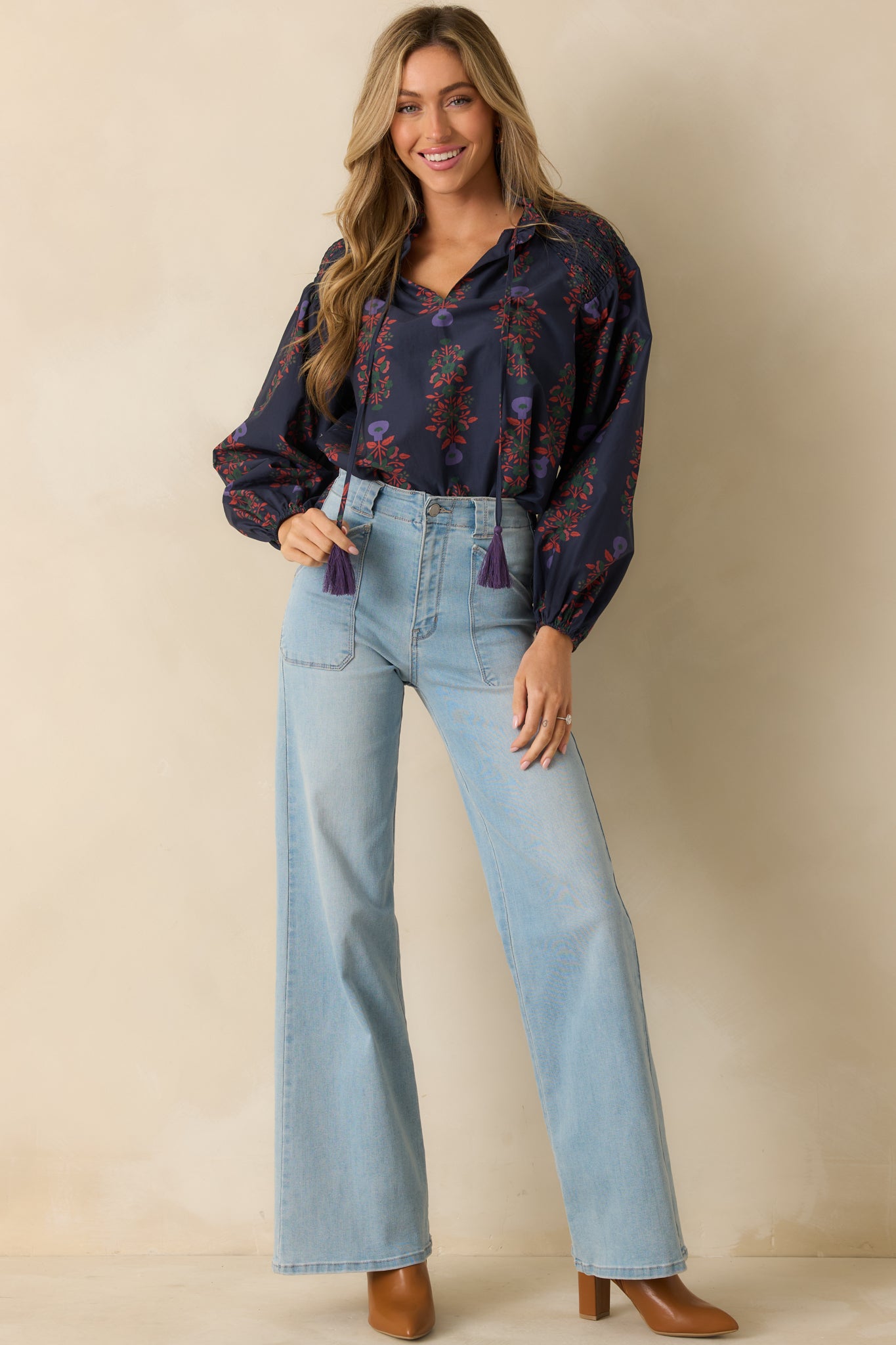 Relaxed navy multi top showcasing smocked detailing, puffed long sleeves, and elasticized cuffs.