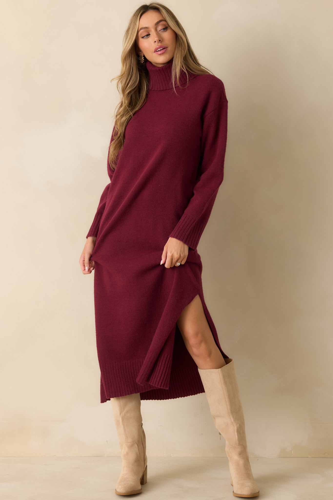 Burgundy knit sweater dress with a turtleneck neckline and long sleeves in a soft stretch fabric.