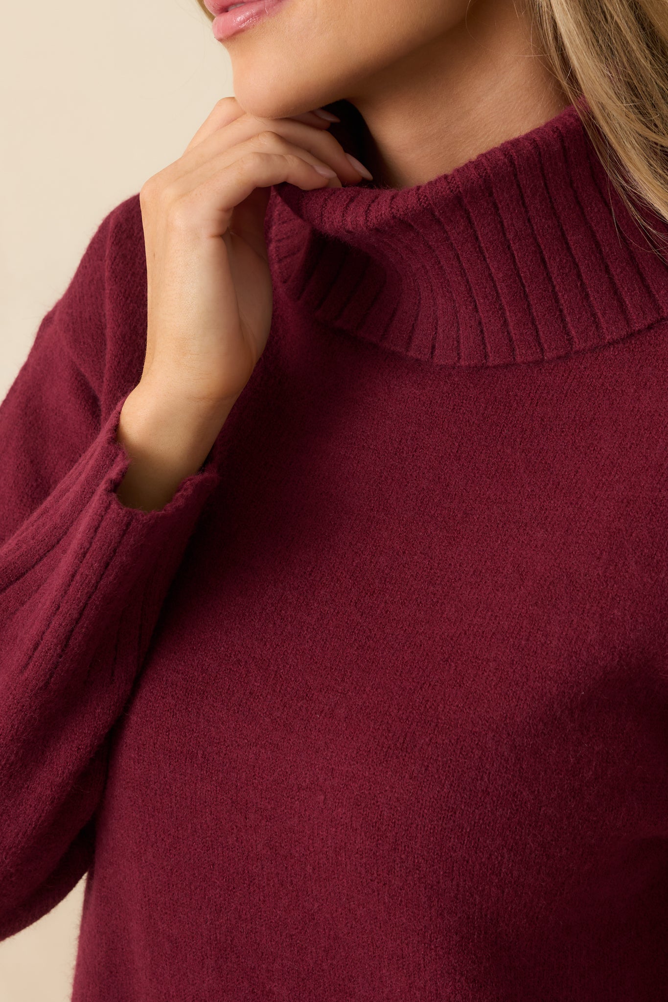 Detailed view of the ribbed knit texture and soft stretch fabric of the burgundy sweater dress.