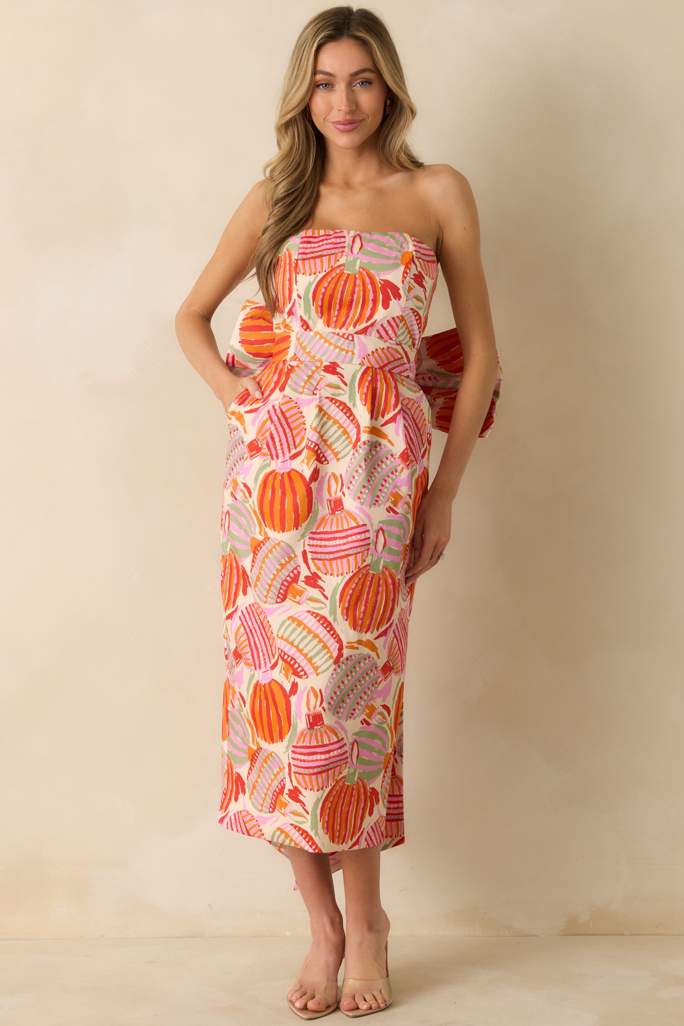 The dress features its sculpted strapless neckline, oversized bow, and flowing asymmetric hemline.