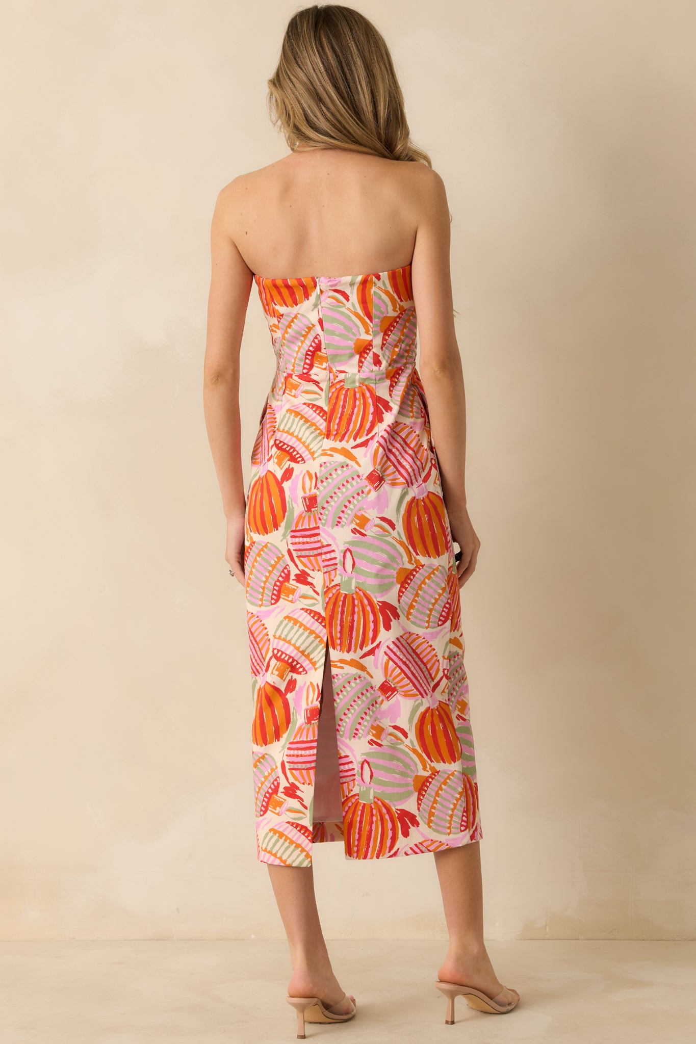 The dress at the rear shows its smooth multicolor print and a concealed zipper framed by full lining for a structured finish.