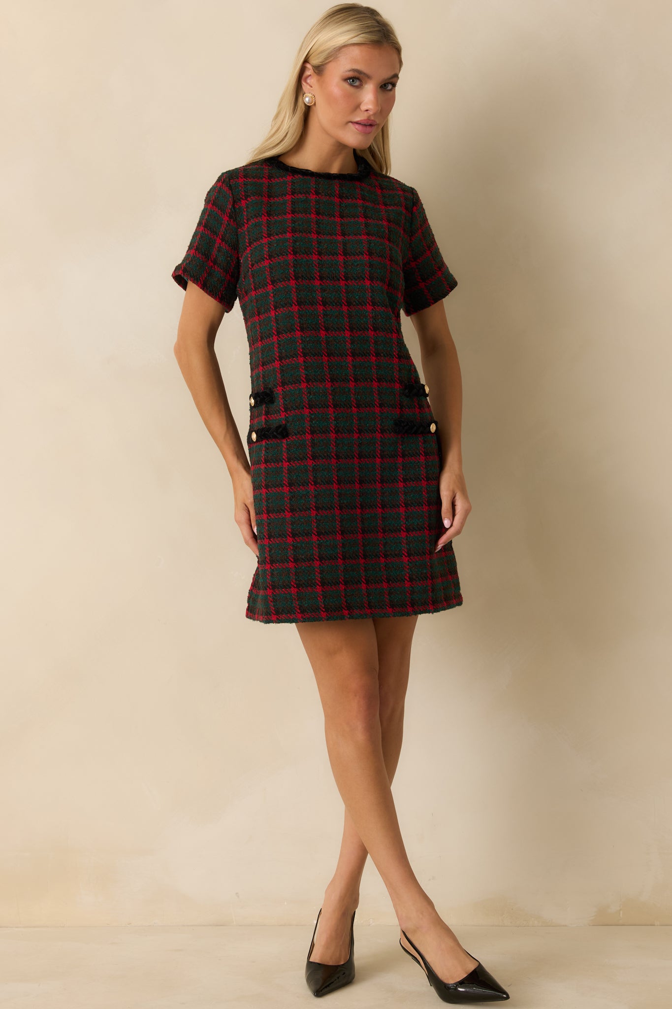 Plaid tweed dress featuring its smooth crew neckline, short sleeve design, and polished trim details framing the front pockets.