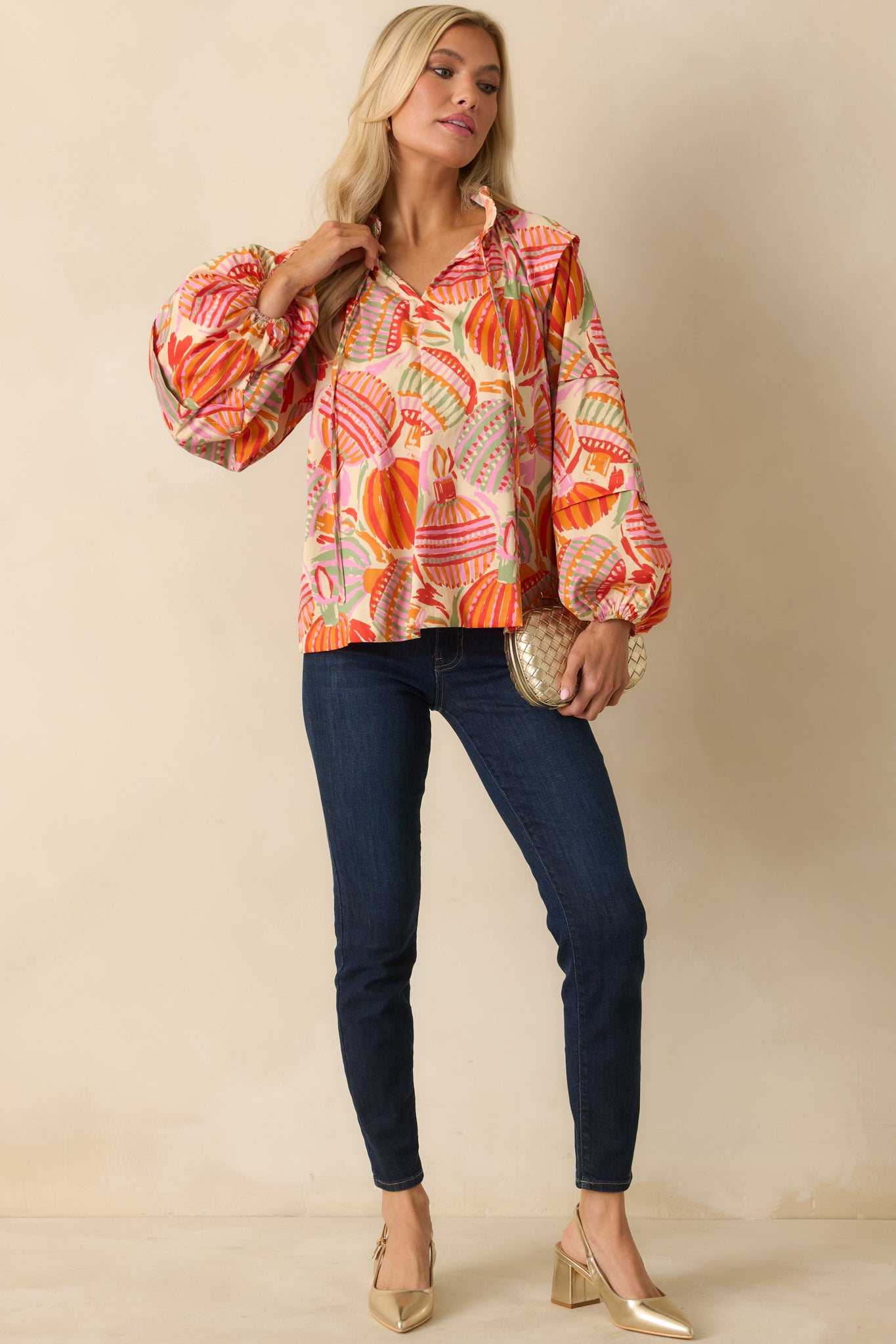 The ornament print stands out across the easy drape of the top, finished with a delicate tie-front neckline.