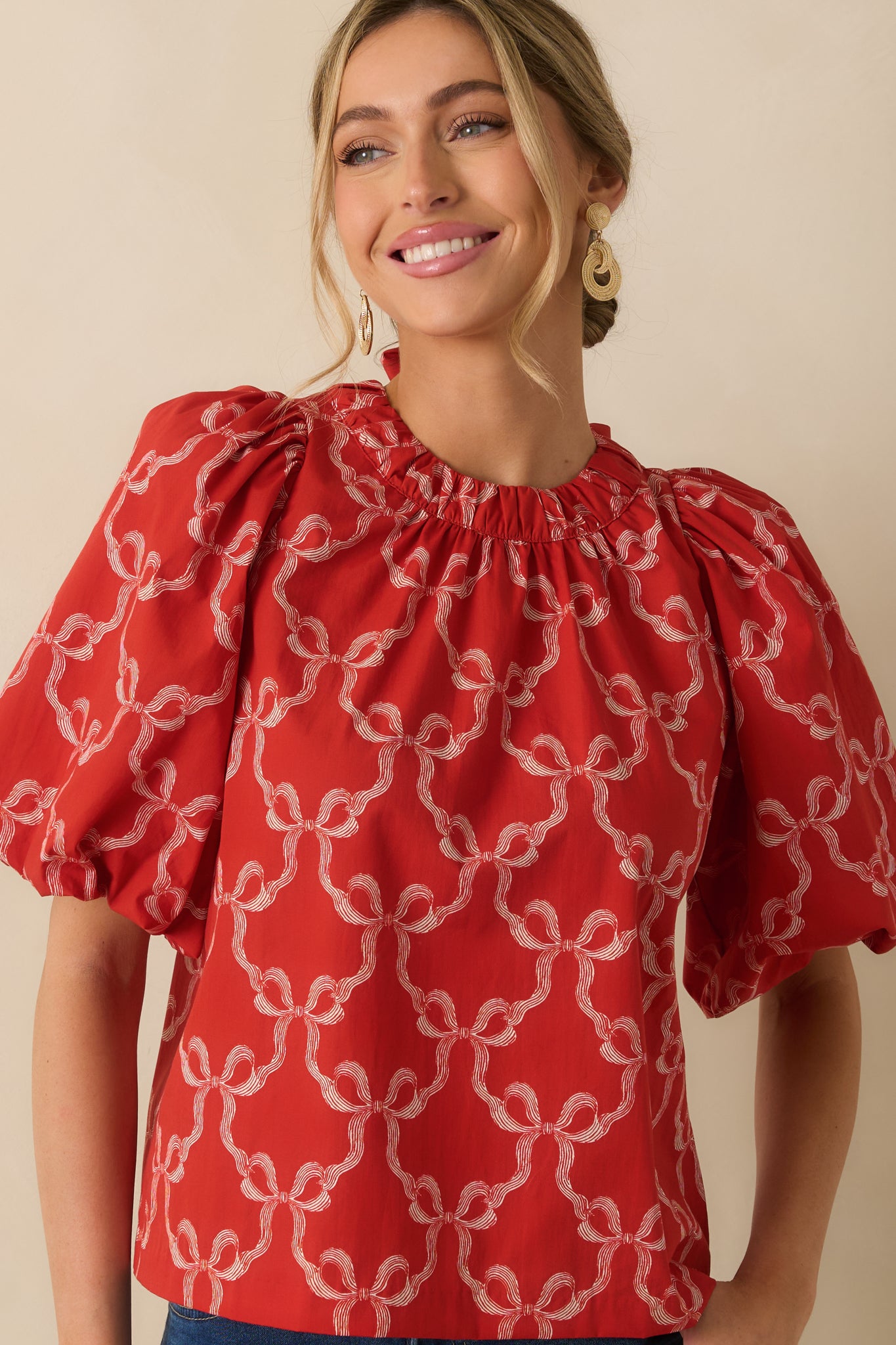 The blouse’s bow print and soft gathers create a playful, textured look on the woven fabric.