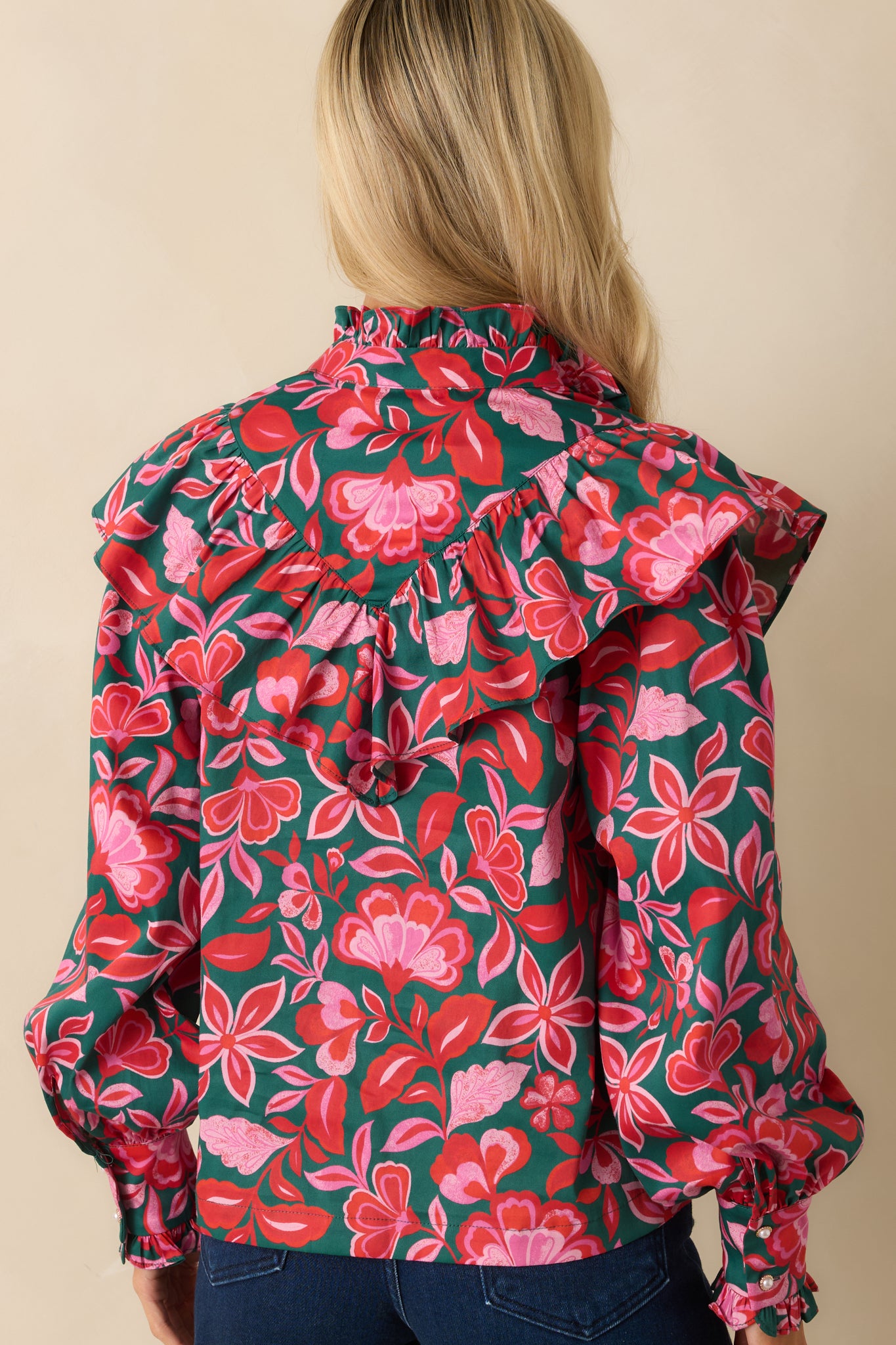 The back of the top shows the relaxed silhouette, gathered long sleeves, and continuous floral print across the cotton fabric.