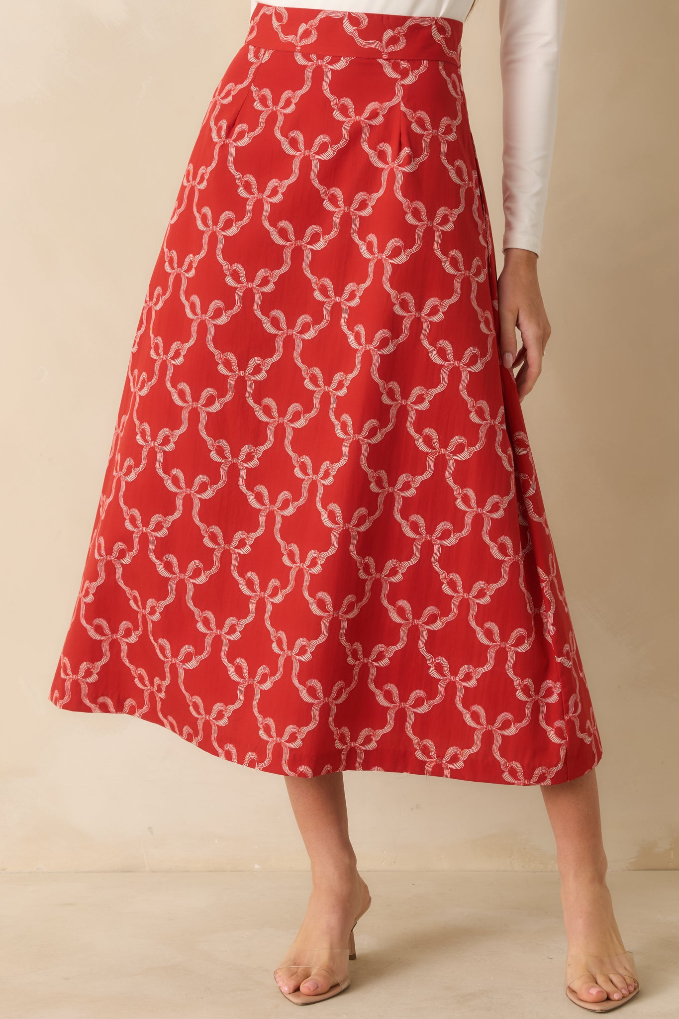 The skirt’s vibrant bow pattern and tailored construction emphasize its structured silhouette.