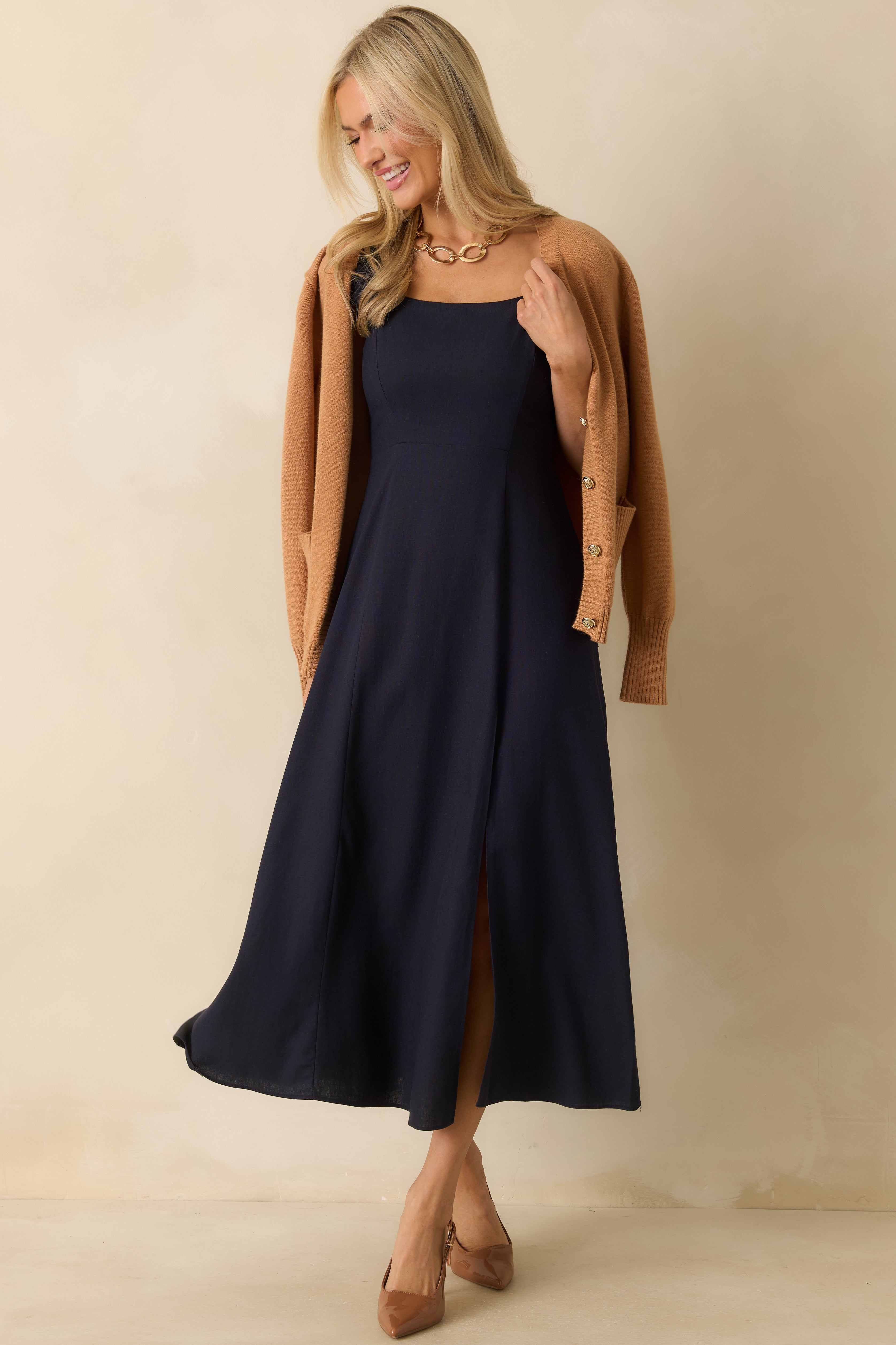 Front view of navy midi dress showing the square neckline, smocked sleeves, and flowy skirt.