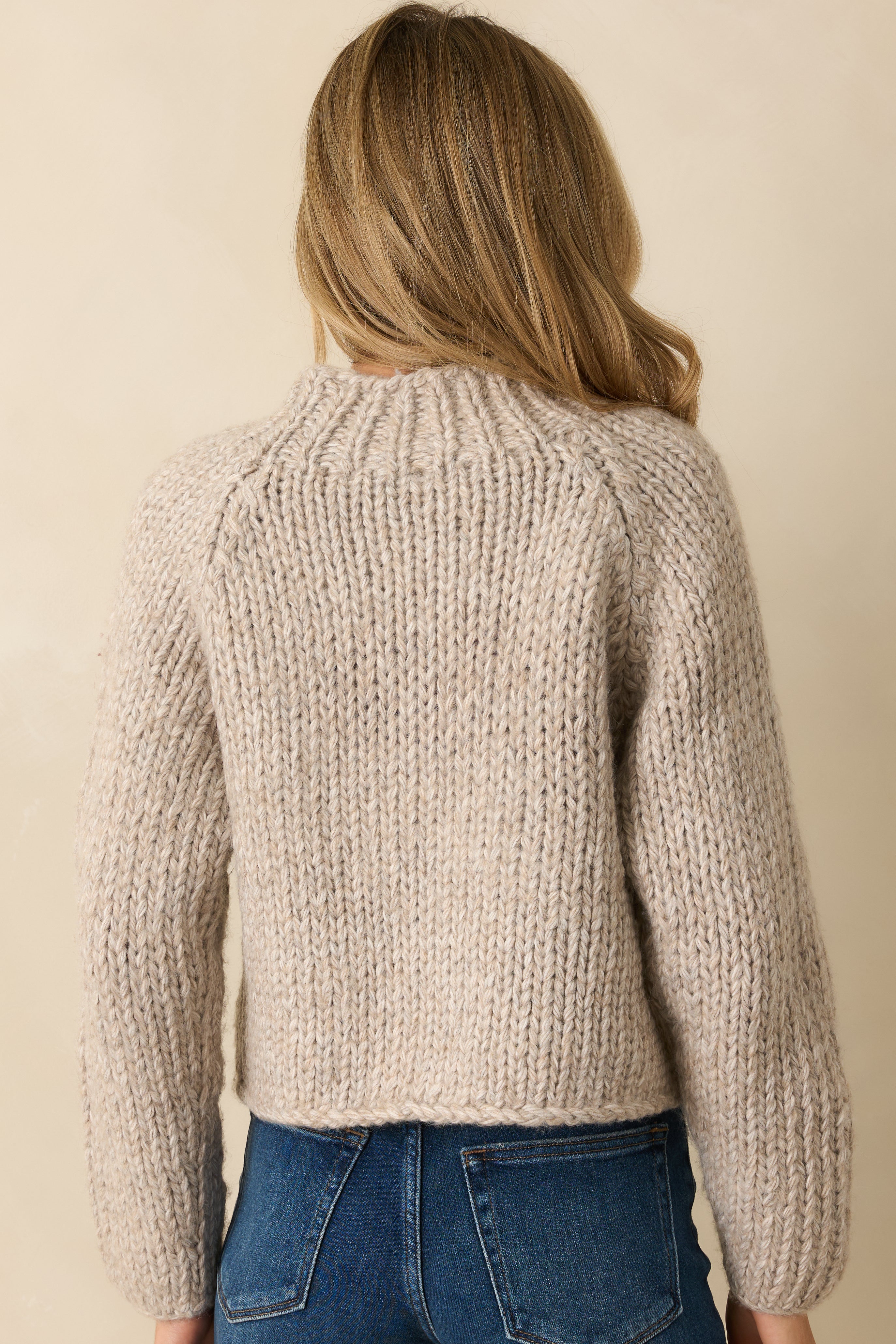 Back view of the cropped sweater showing the relaxed fit, long sleeves, and full textured knit.