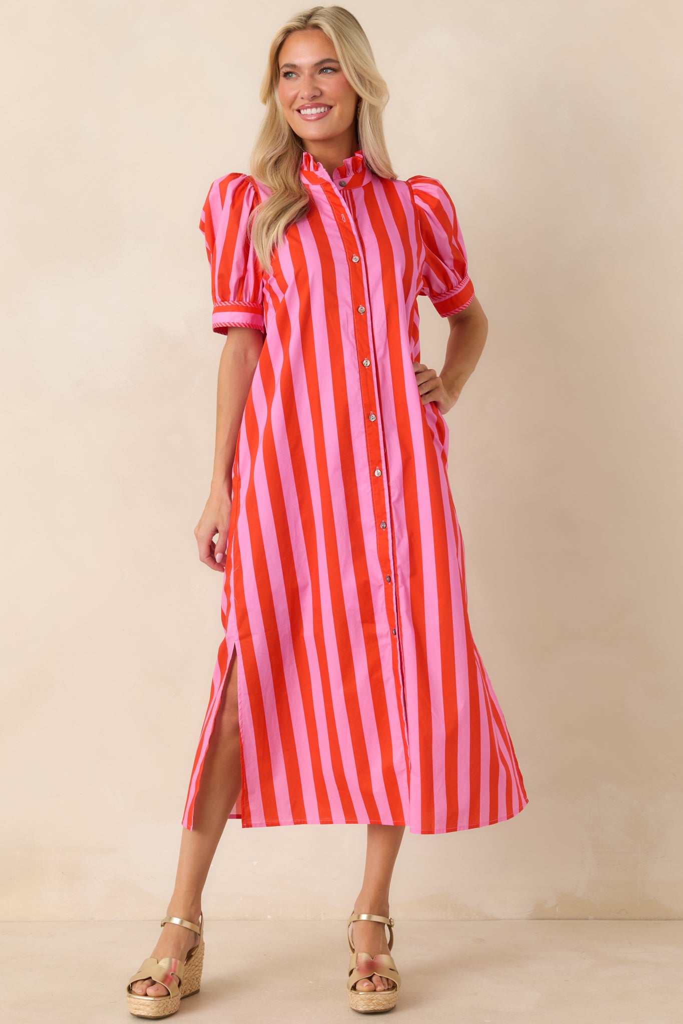 Pink and red vertical stripe midi dress featuring a button front closure, short puff sleeves, and side pockets.