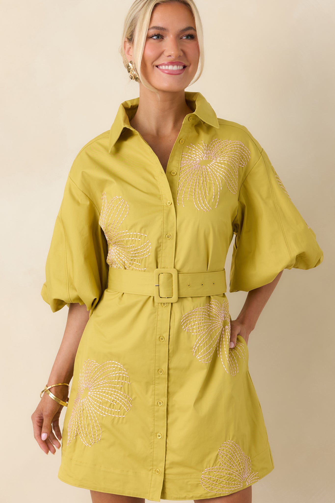 Collared neckline and button-front detail with delicate light pink embroidery on cotton fabric.