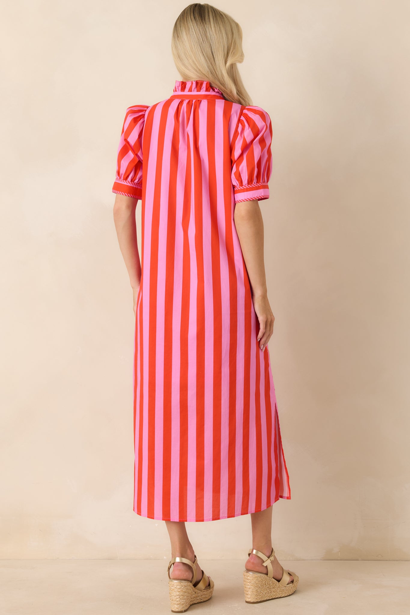 Rear view of pink and red striped midi dress featuring short puff sleeves and a clean flowing silhouette.