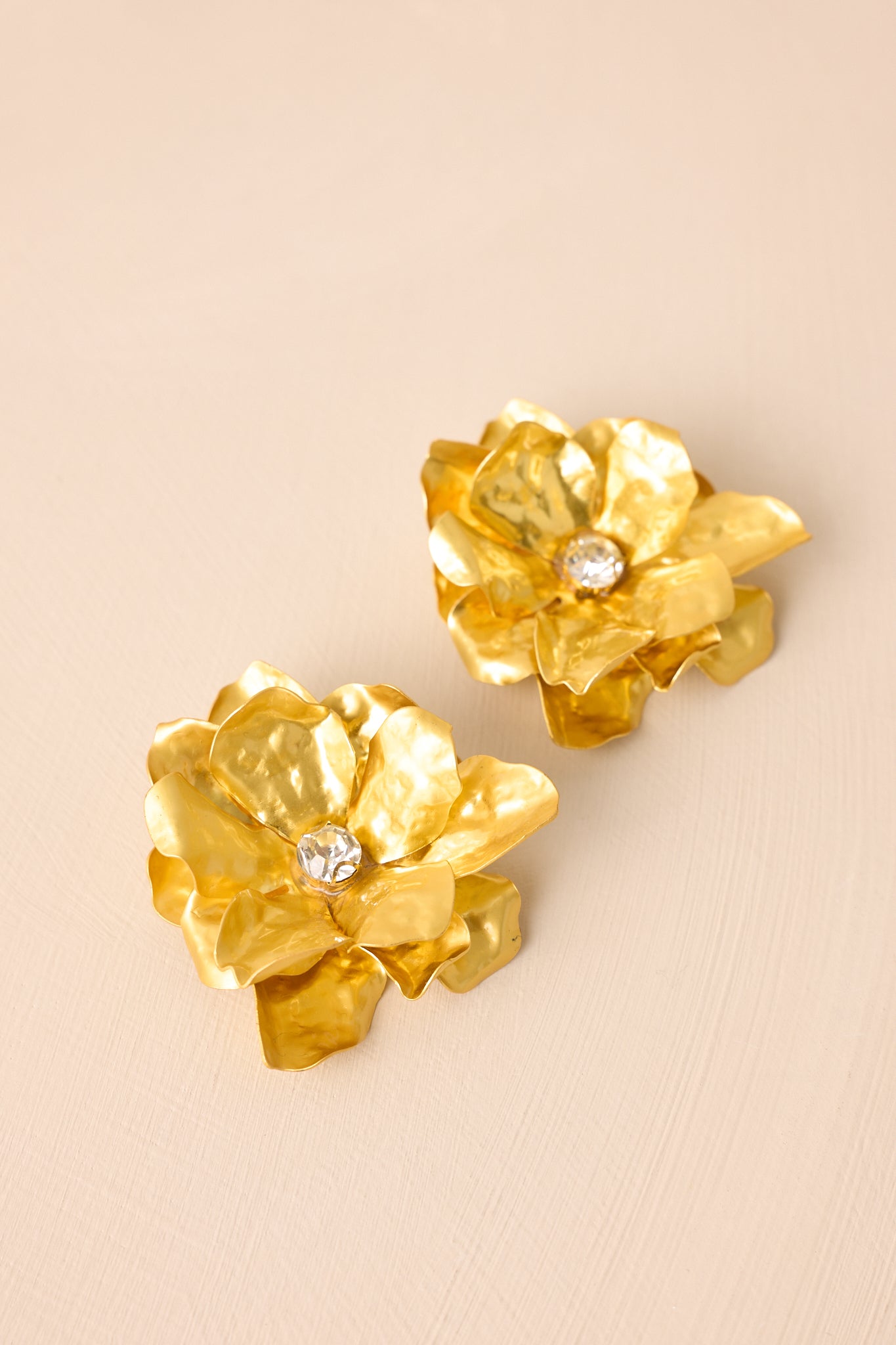 Side-angle crop emphasizing the depth of the floral design and secure post backings of the earrings.