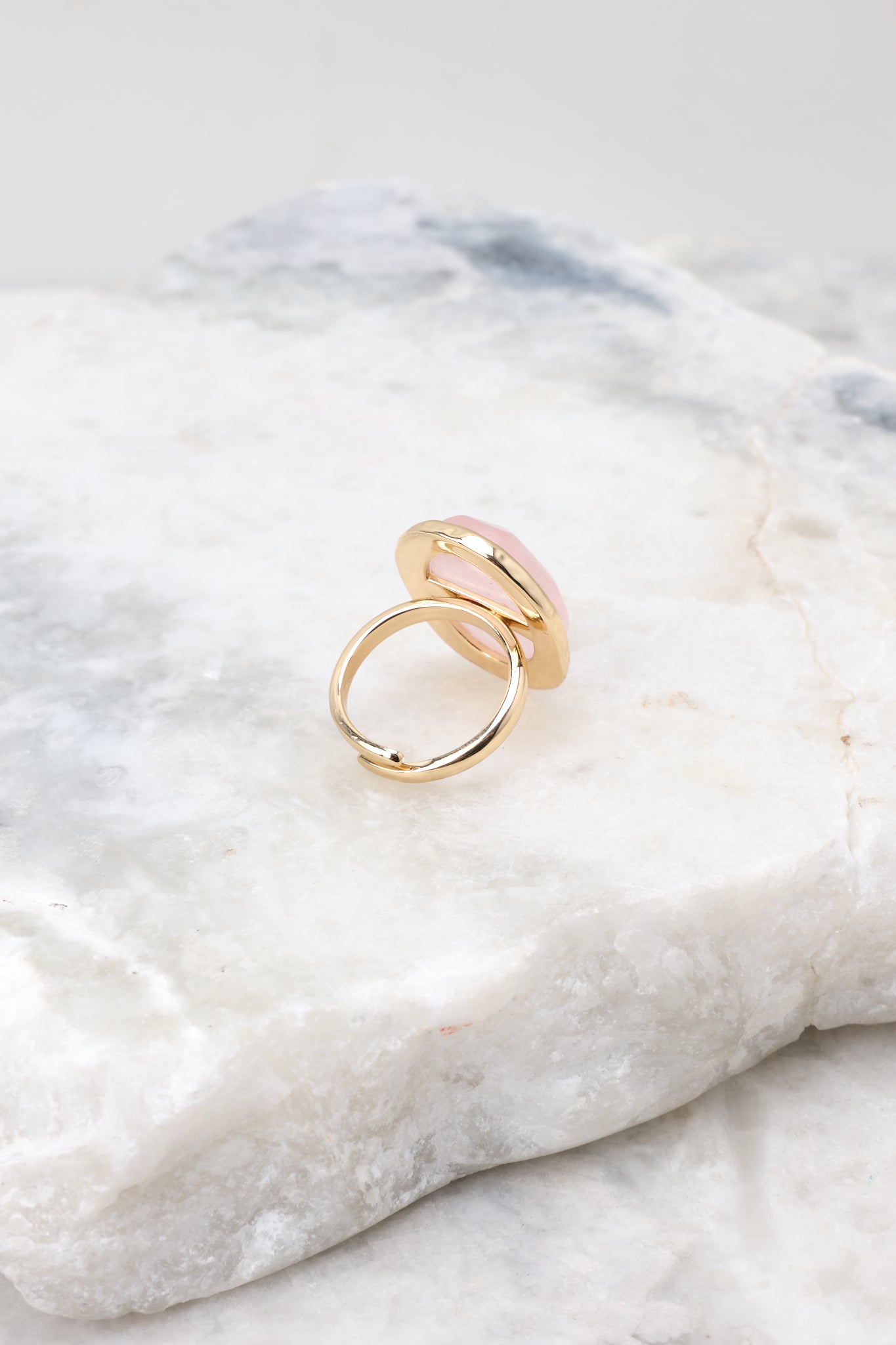 Front view of rose quarts ring with an adjustable gold band.