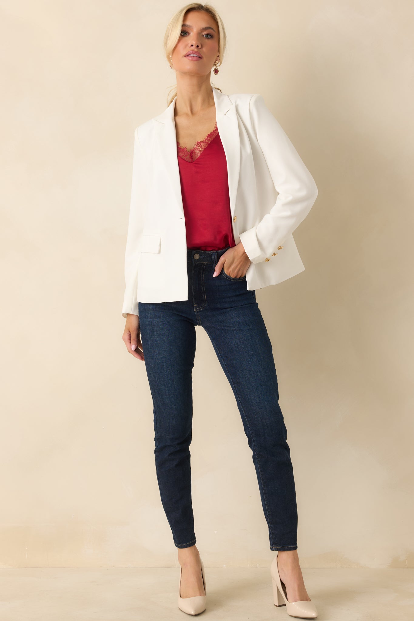 Front view of white blazer showcasing structured fit, gold button accents, and clean V-neckline.