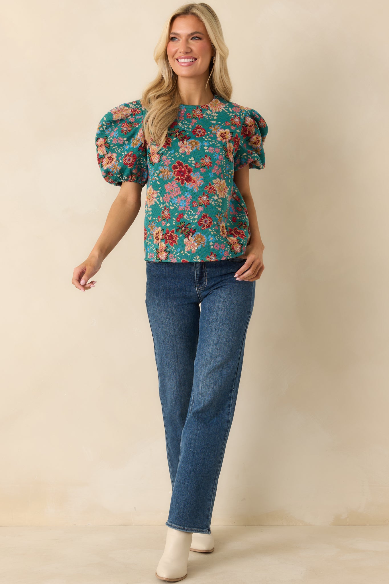 Floral-print teal-green top featuring gathered shoulder detailing and a lightly tailored bodice.