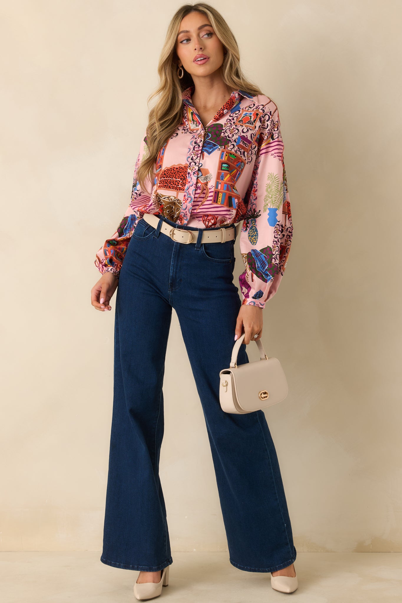 The blouse shows the vibrant pink multi-color print paired with structured cuffs and a flowing fit.
