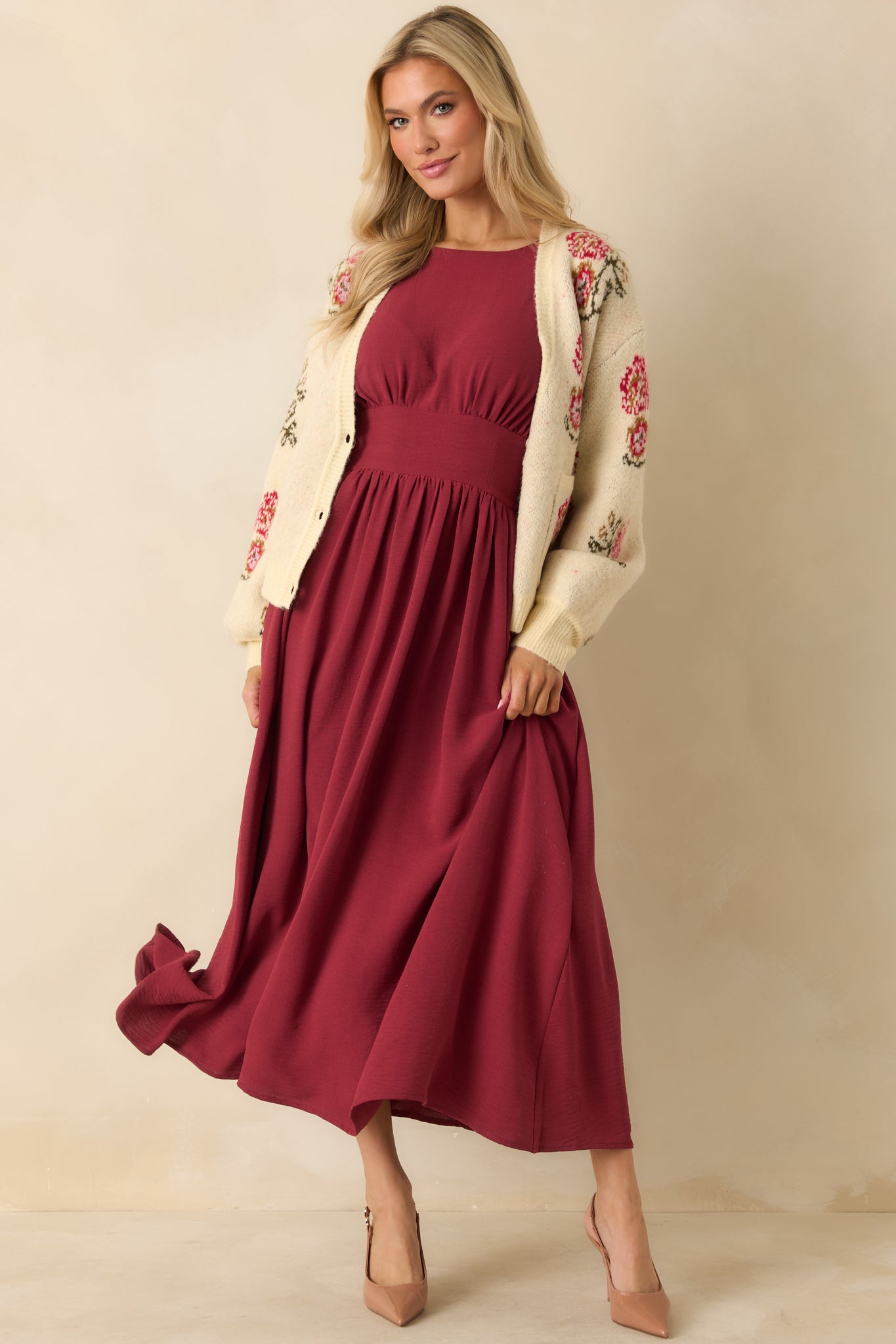 Burgundy dress showing smooth fabric, functional front pockets, and structured waist detailing.
