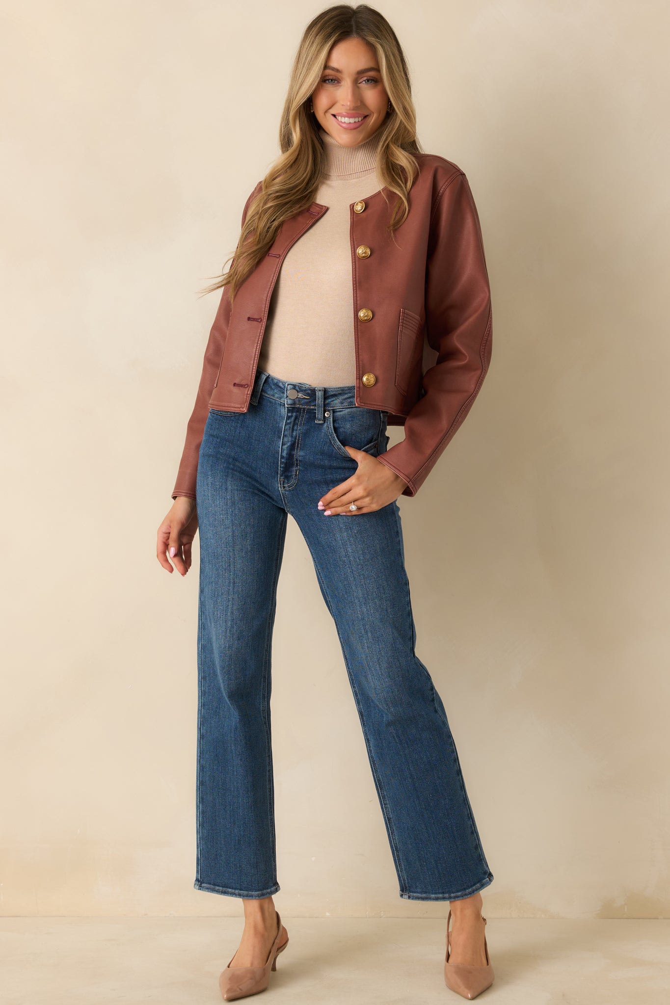 Faux leather jacket displaying welt pockets, long sleeves, and clean edges.