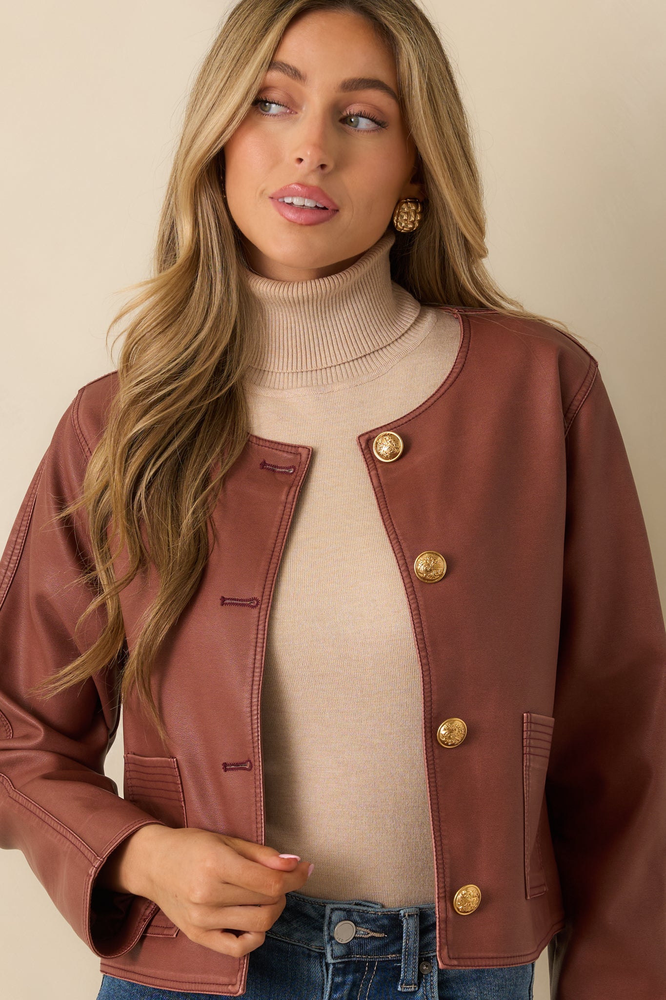 Front view focusing on the embossed gold buttons and smooth mauve leather texture.