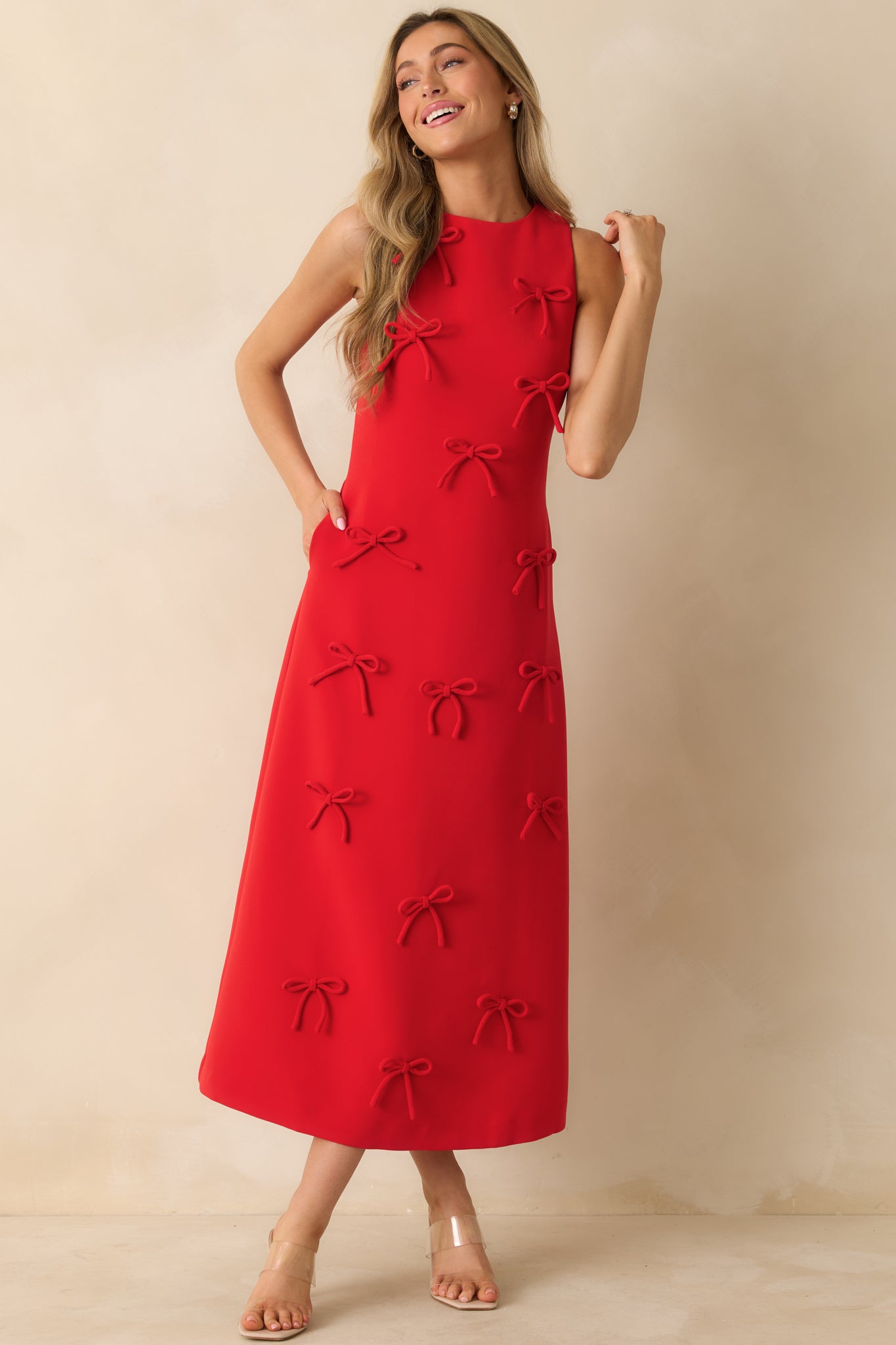 Full-length front view of the red maxi dress highlighting the straight silhouette, bow appliqués, and side pockets.